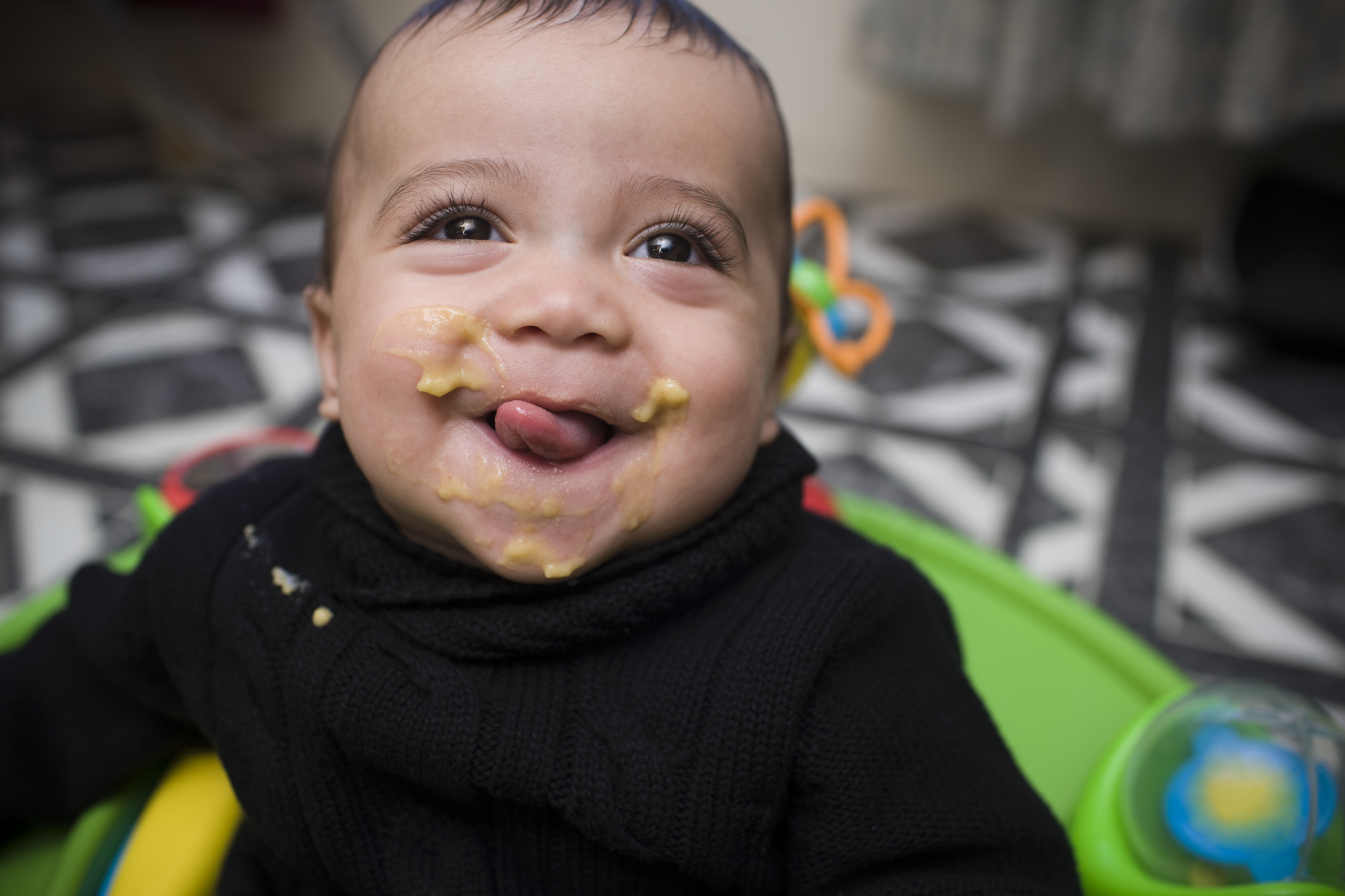 Adorable Hispanic Baby Boy Eating in High Chair, Copy Space