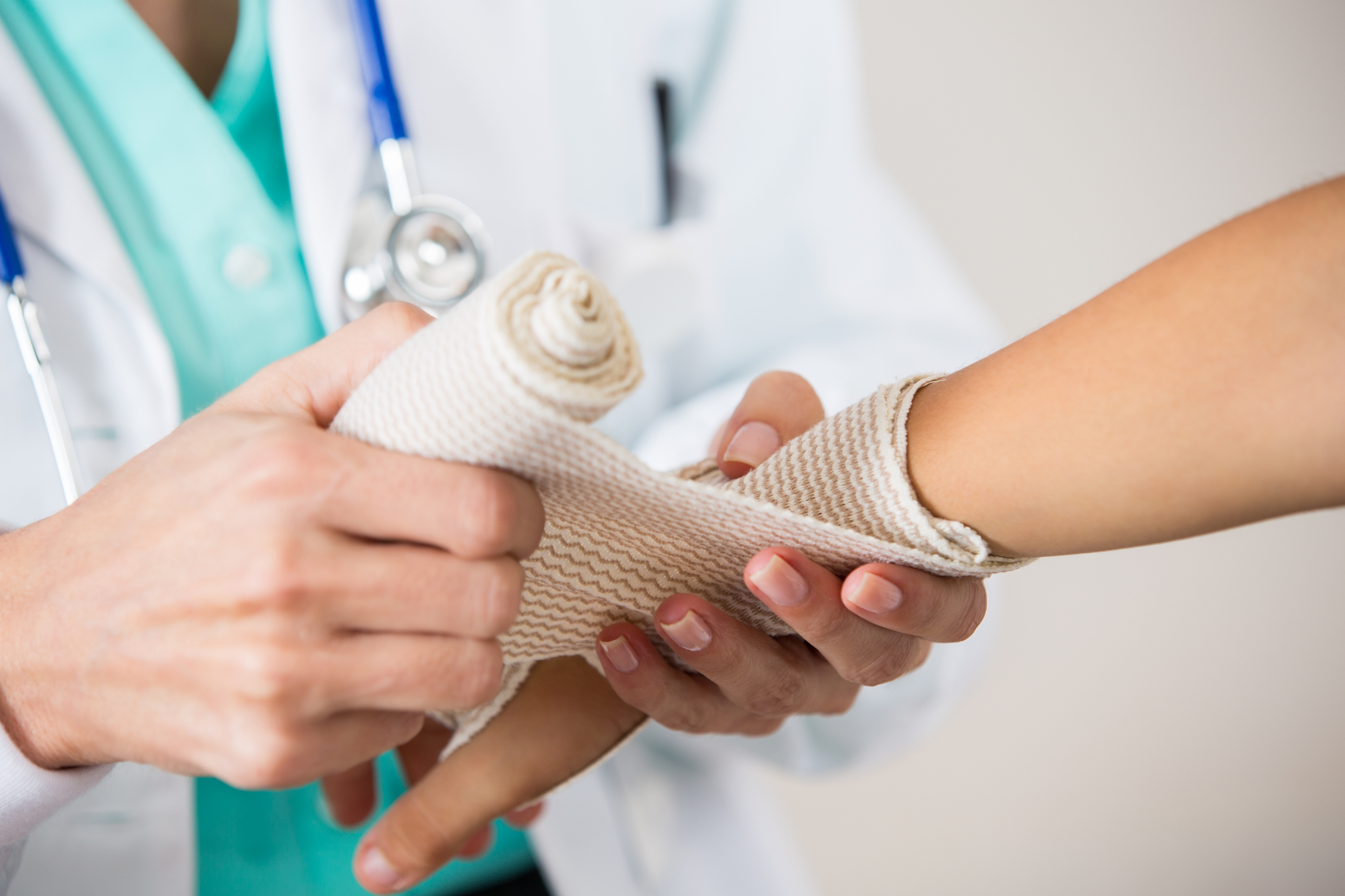 Pediatrician wrapping wrist of patient during exam