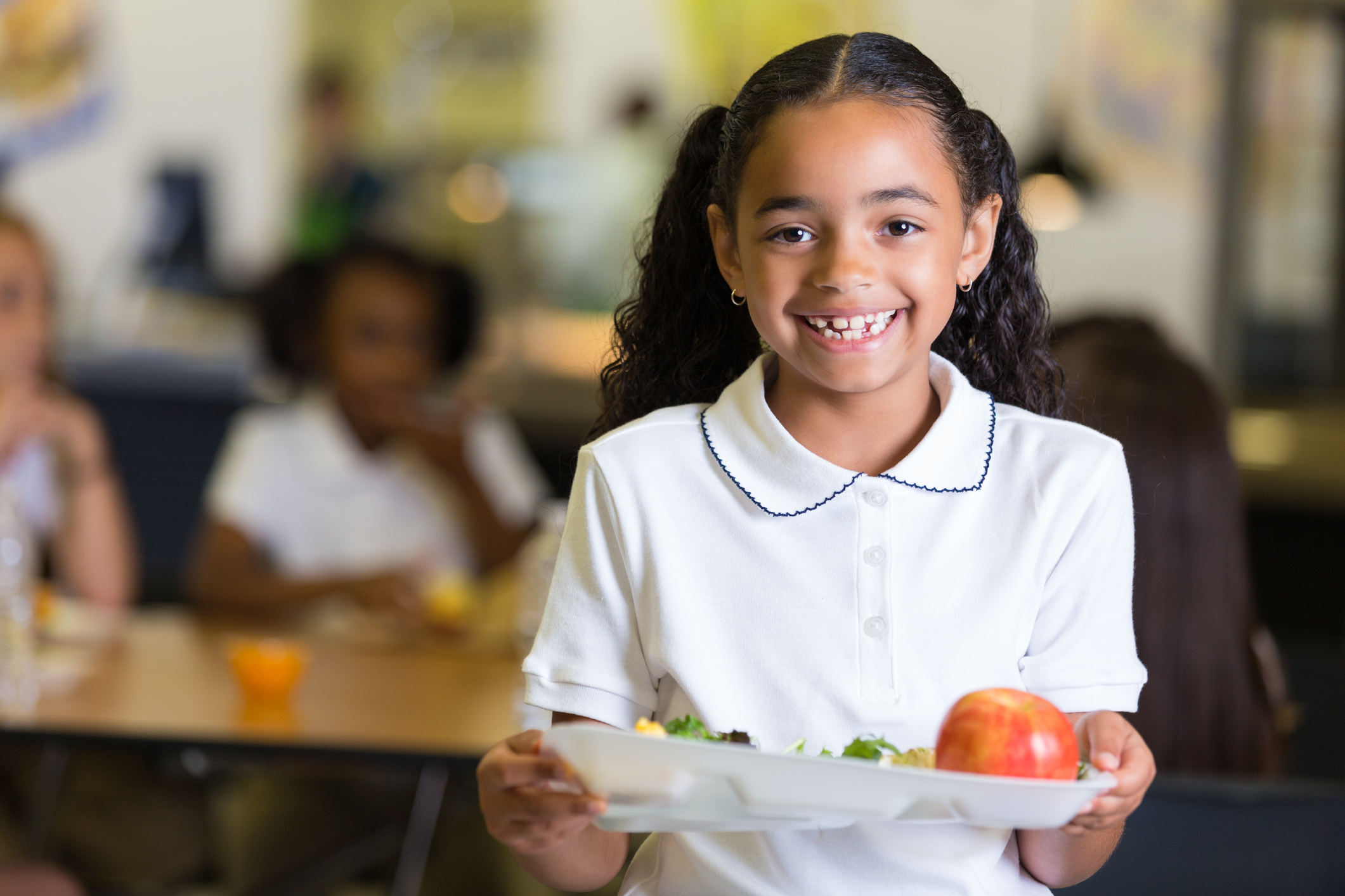 Cute little girl in school cafeteria with food tray