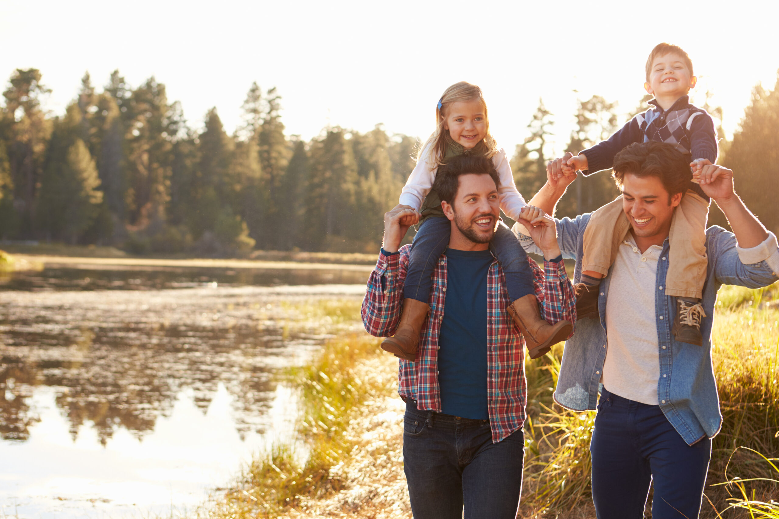 Gay Male Couple With Children Walking By Lake