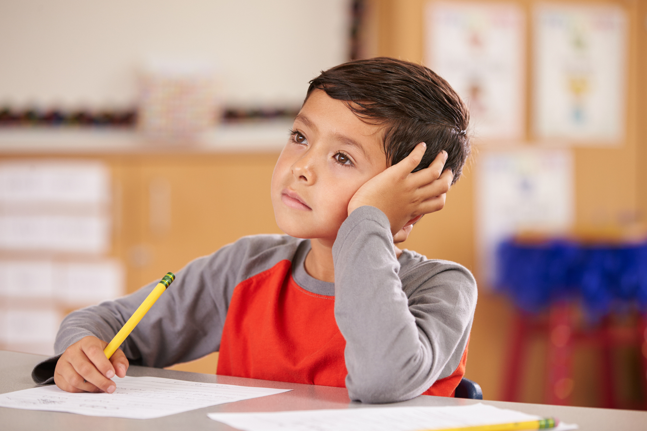 Portrait of a boy daydreaming in an elementary school class