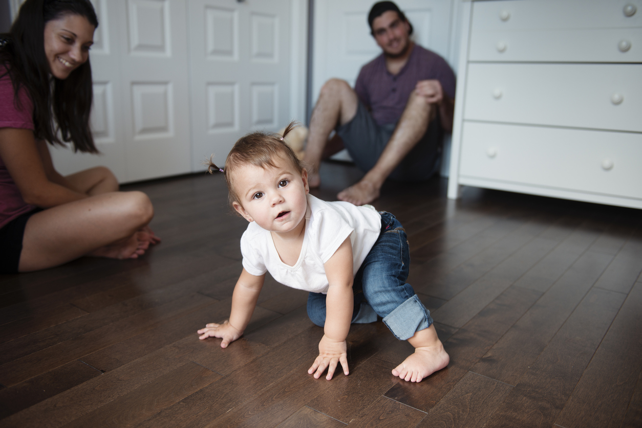 Baby girl is walking with the help of the hands