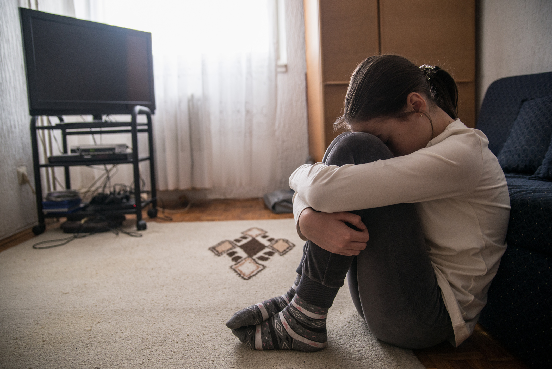 Teen woman with headache holding her head