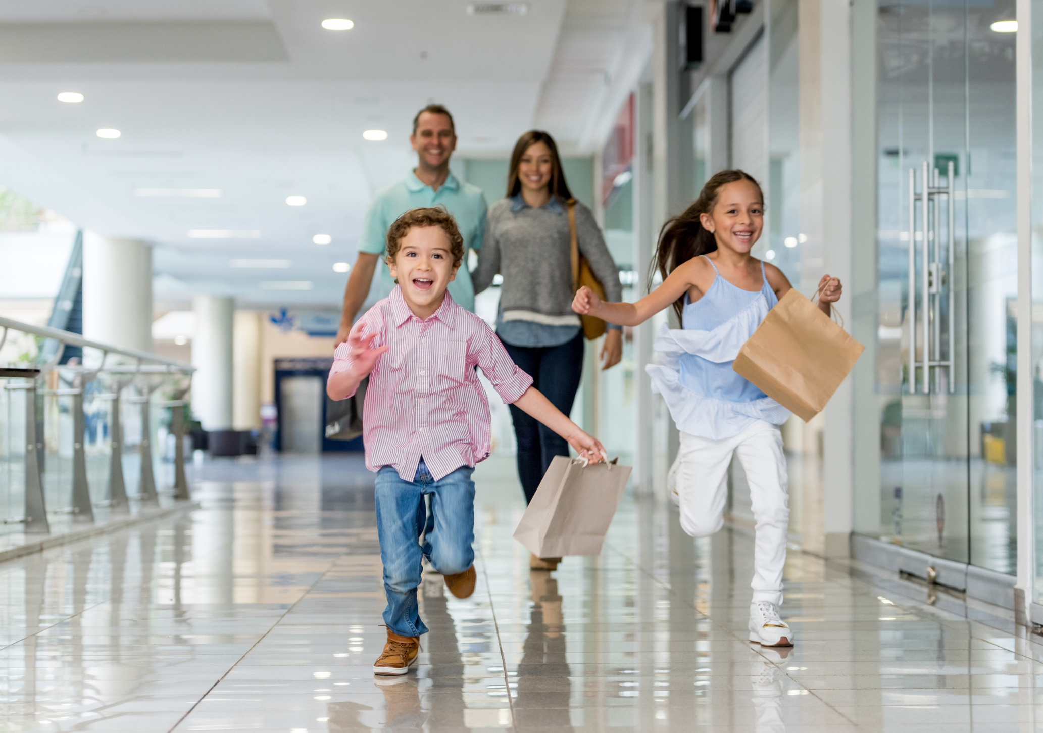 Family shopping and running towards the camera at the mall