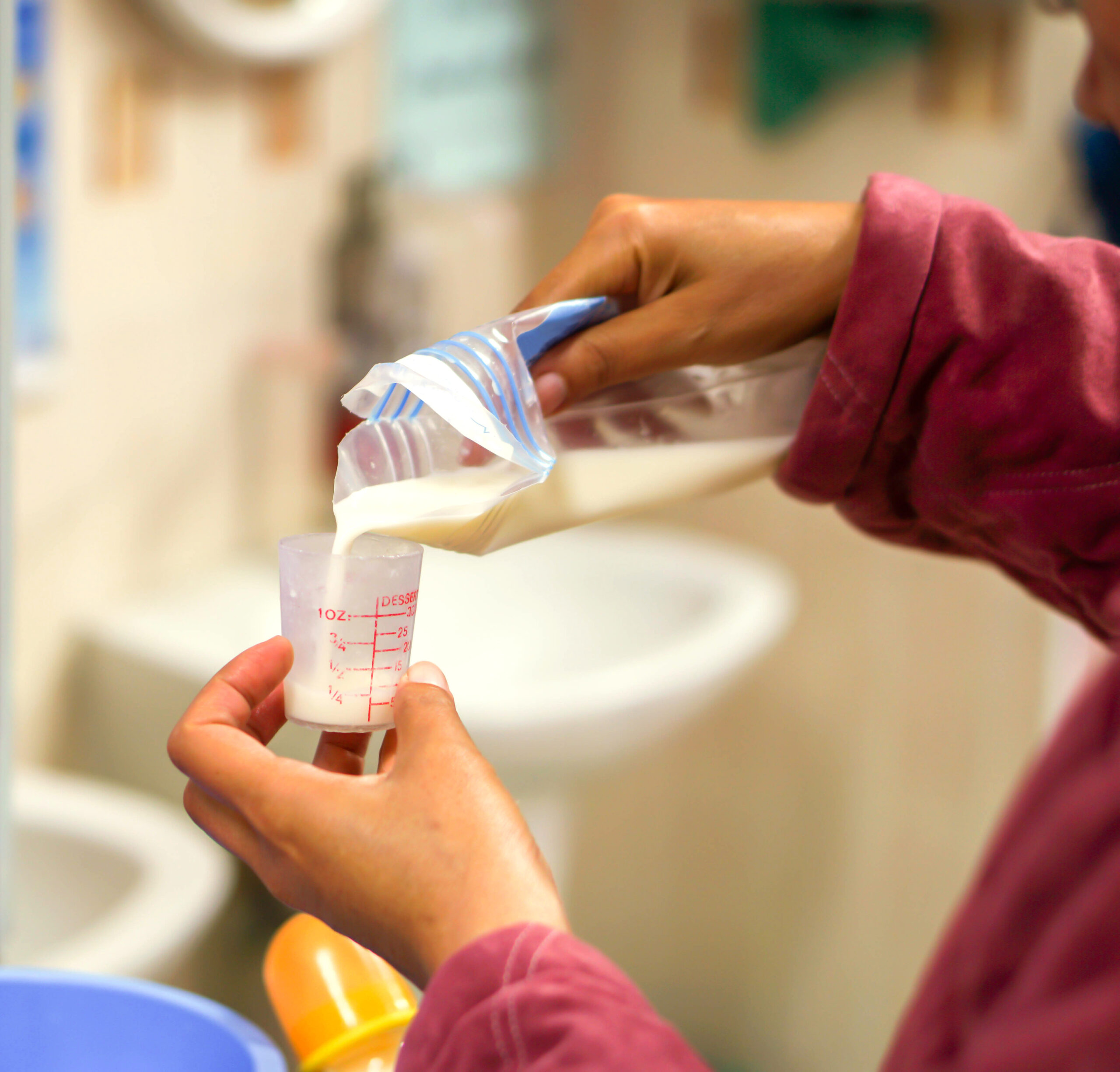 Nurse's hands is pouring mother's fresh milk