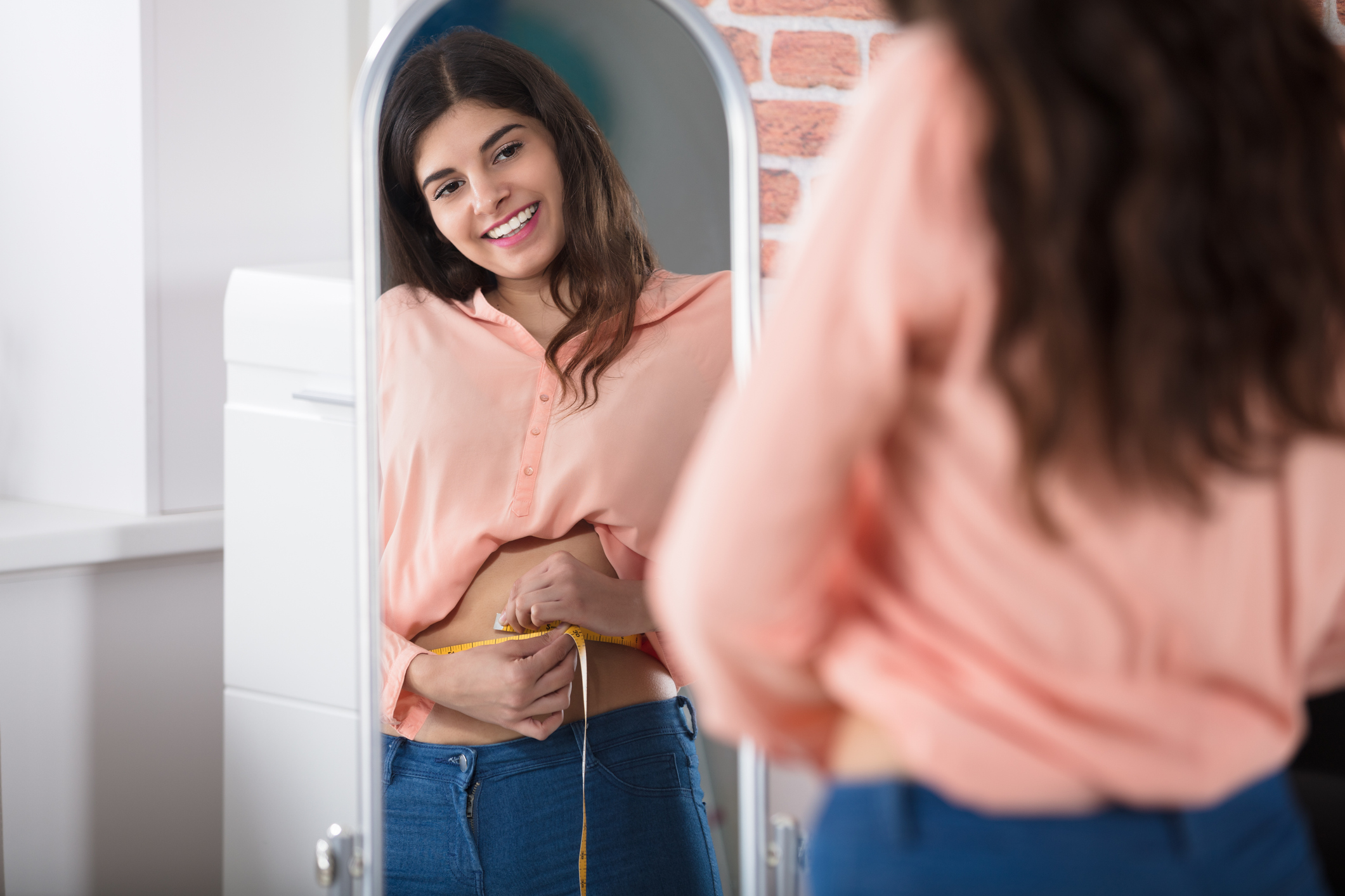 Happy Woman Measuring Waist With A Tape