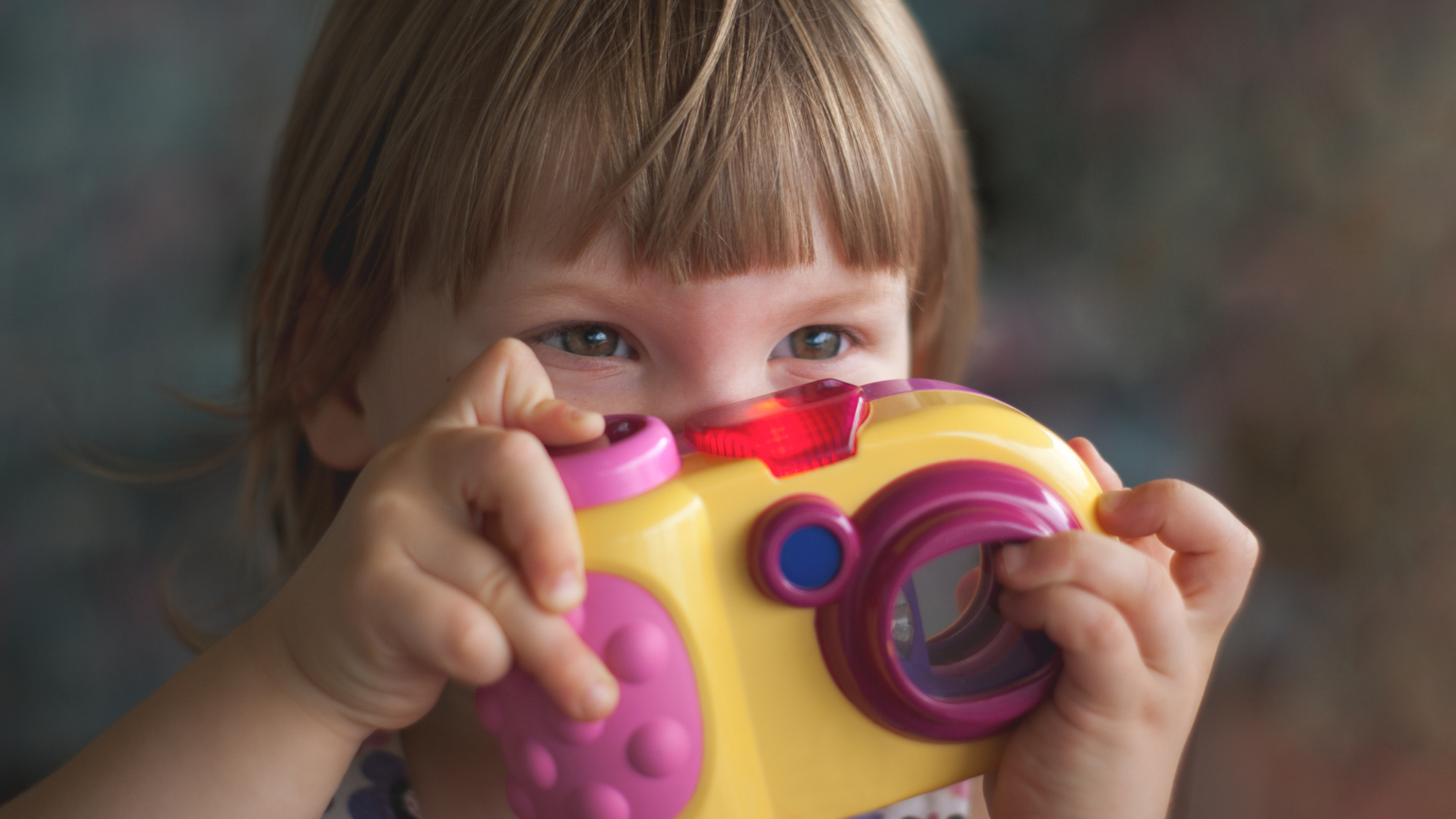 niña con cámara de juguete