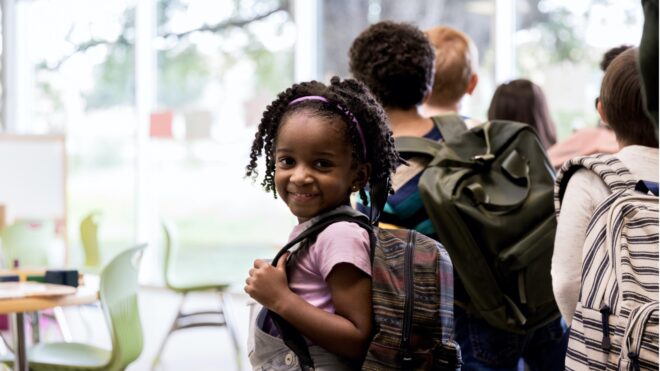 Niña con mochila sonriendo