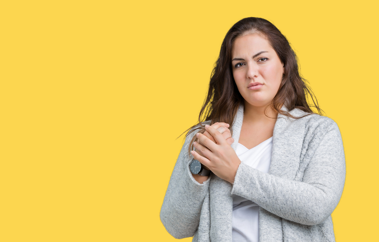 Beautiful plus size young woman wearing winter jacket over isolated background Suffering pain on hands and fingers, arthritis inflammation