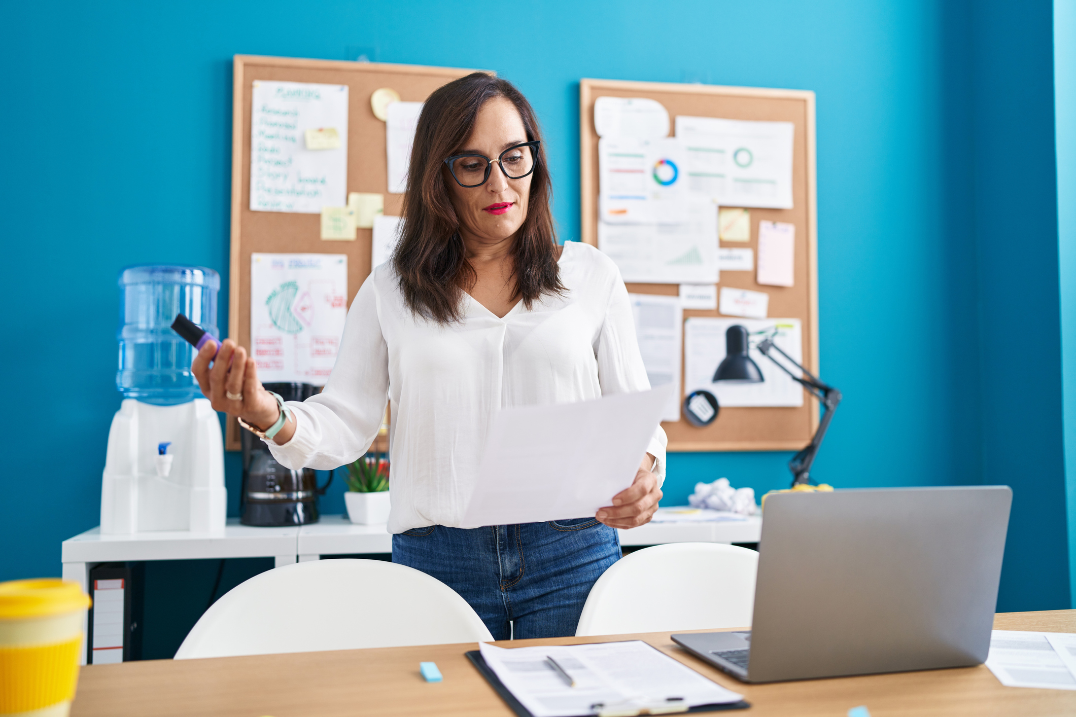 Young beautiful hispanic woman business worker standing by desk speaking at office