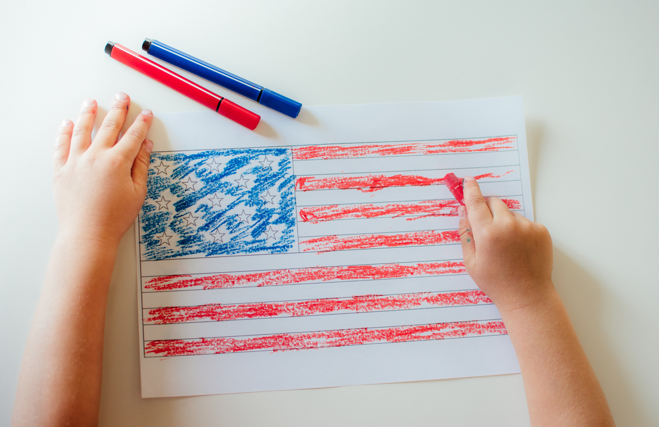 The child draws the flag of America.