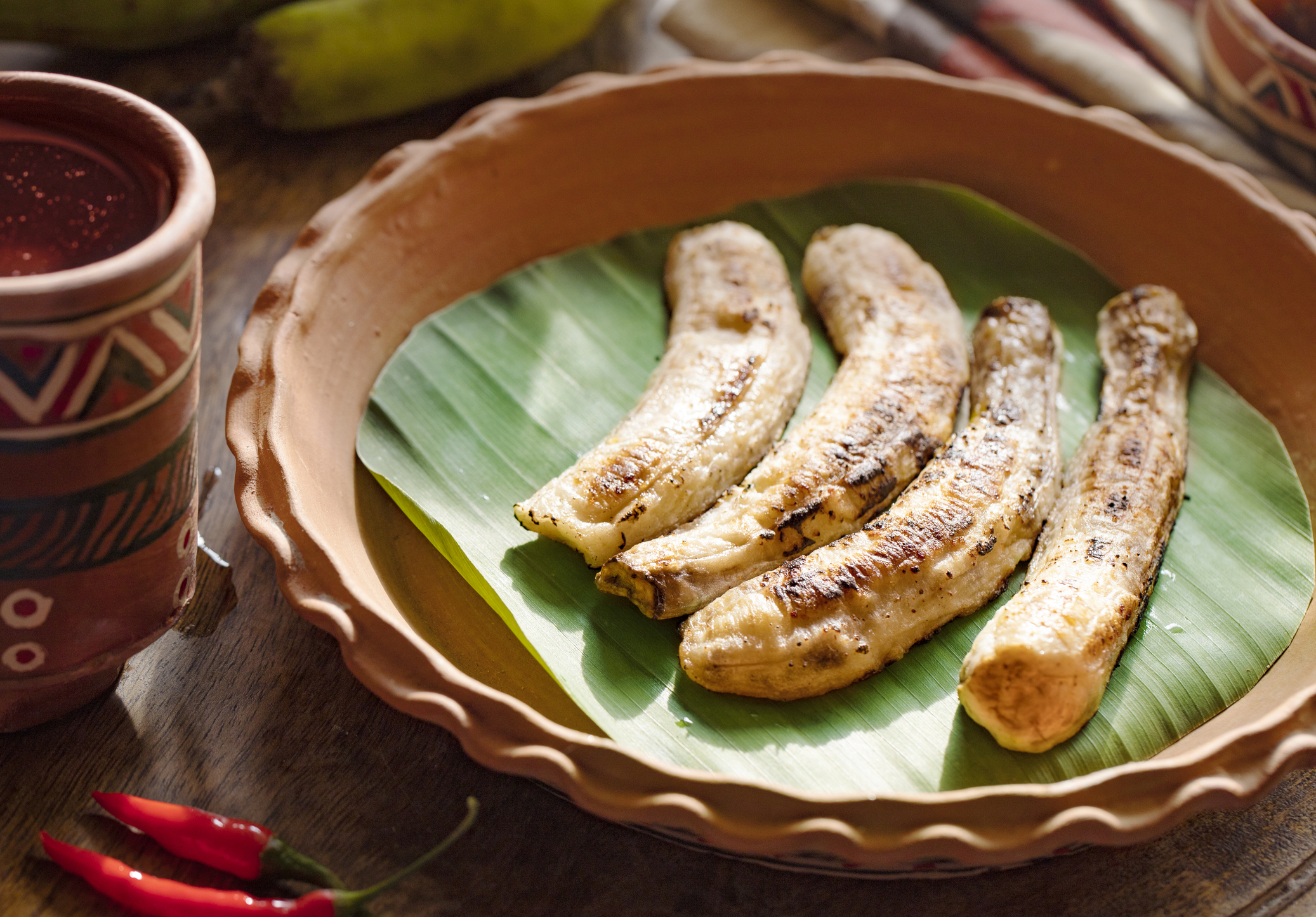 african food. African cuisine called Boli - fried bananas plantains. Grilled Bananas. African tourism. chili plantains with spicy tomato sauce. food concept. Traditional African and Nigerian cuisine.