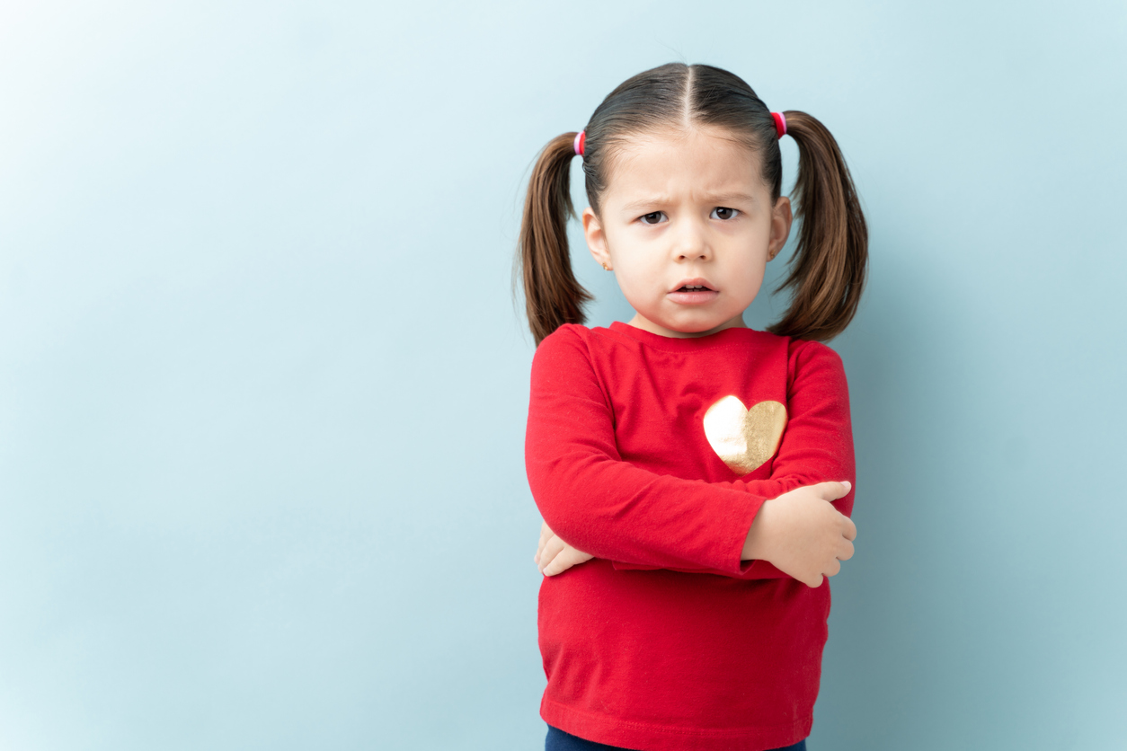 Serious little girl with arms crossed