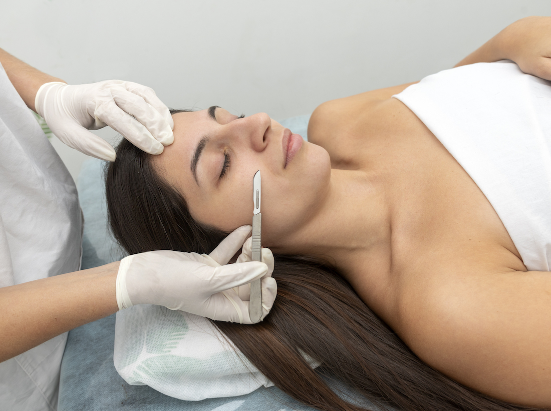 Hispanic female patient with eyes closed in the cosmetic clinic preparing for dermaplaning treatment