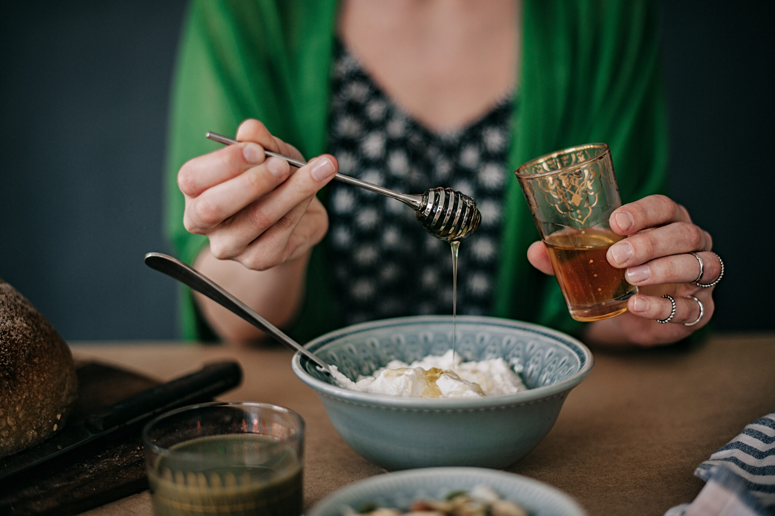 Woman preparing breakfast yogurt and honey