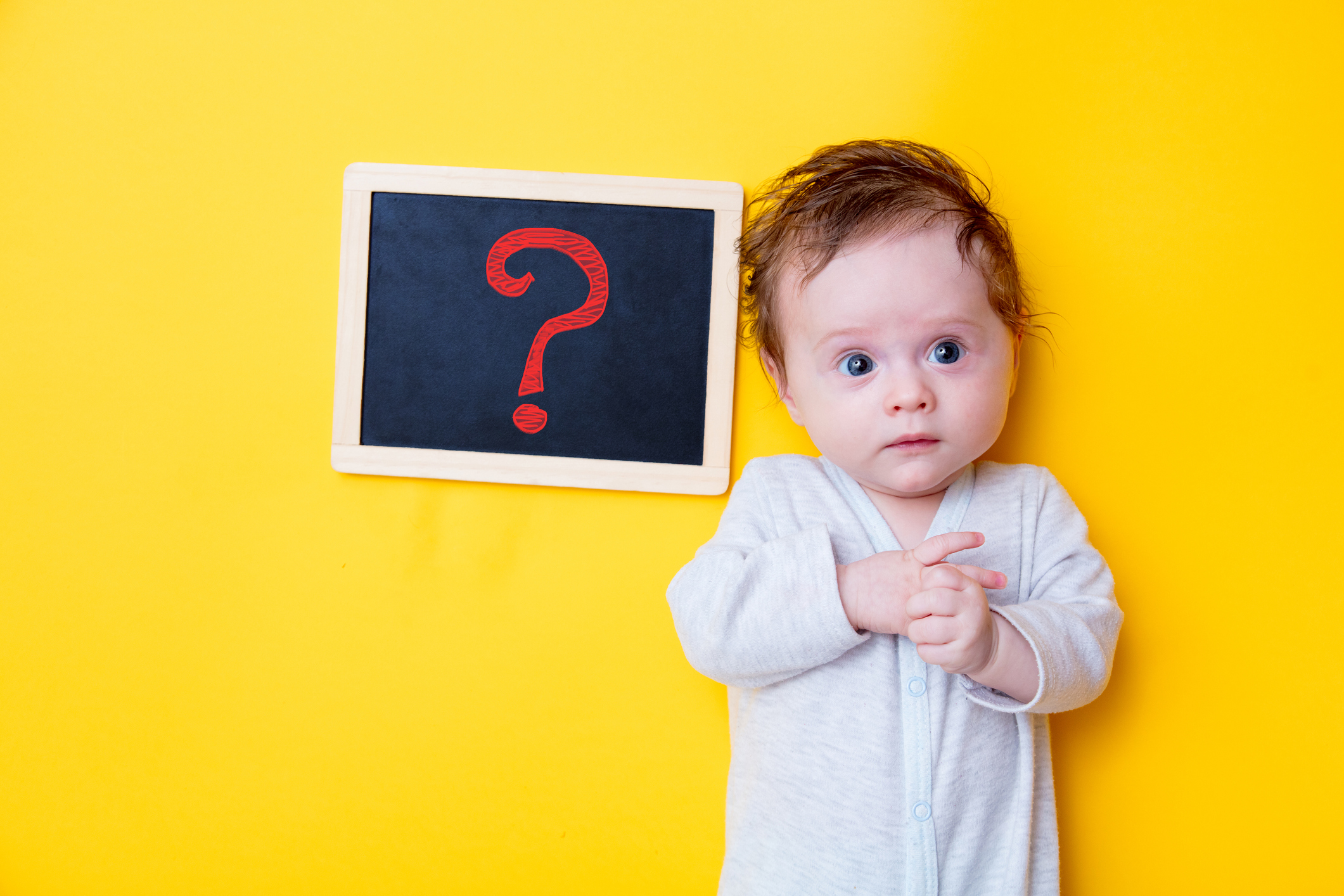 little baby with black board and red question