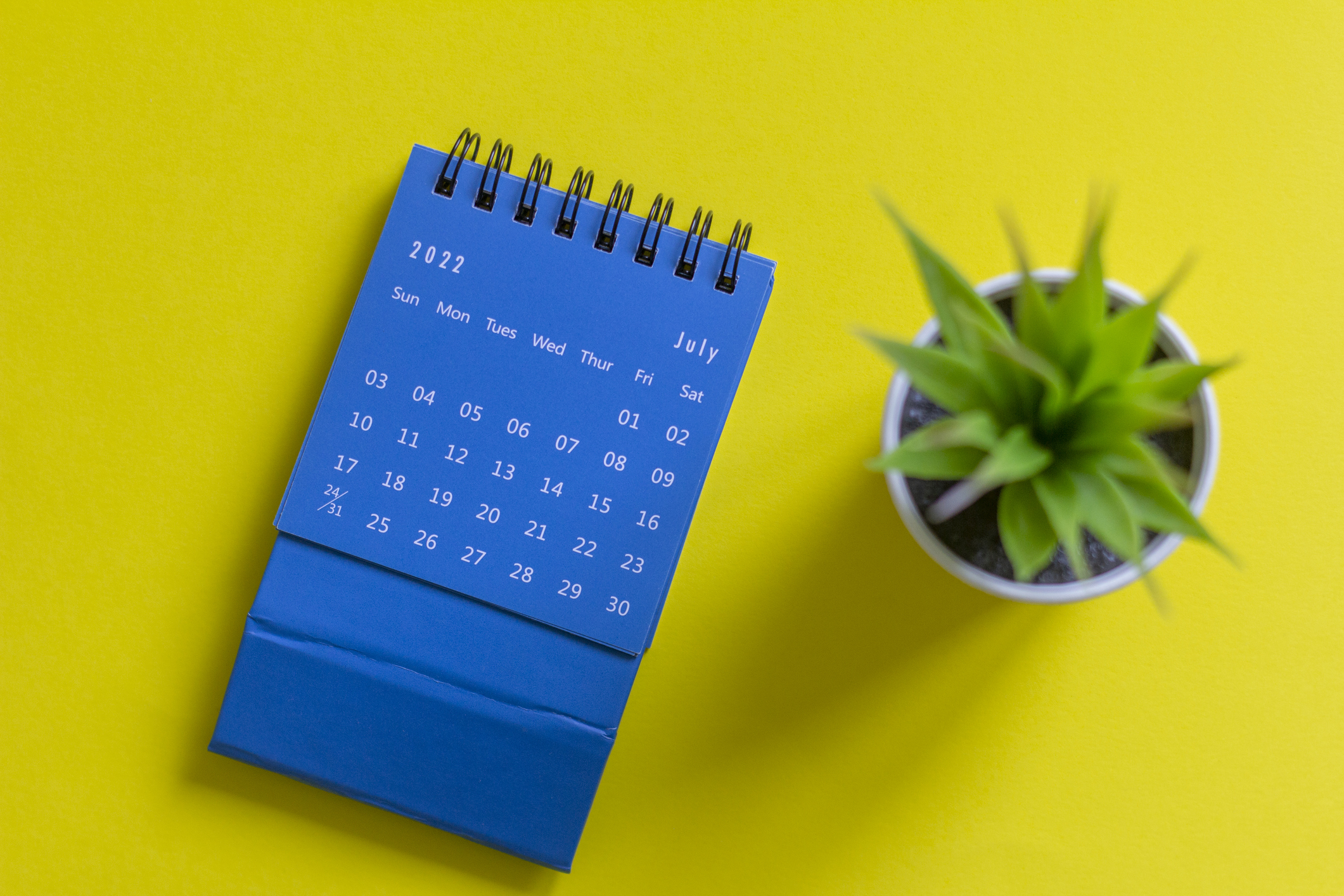 Desk calendar for July 2022 on a yellow background.