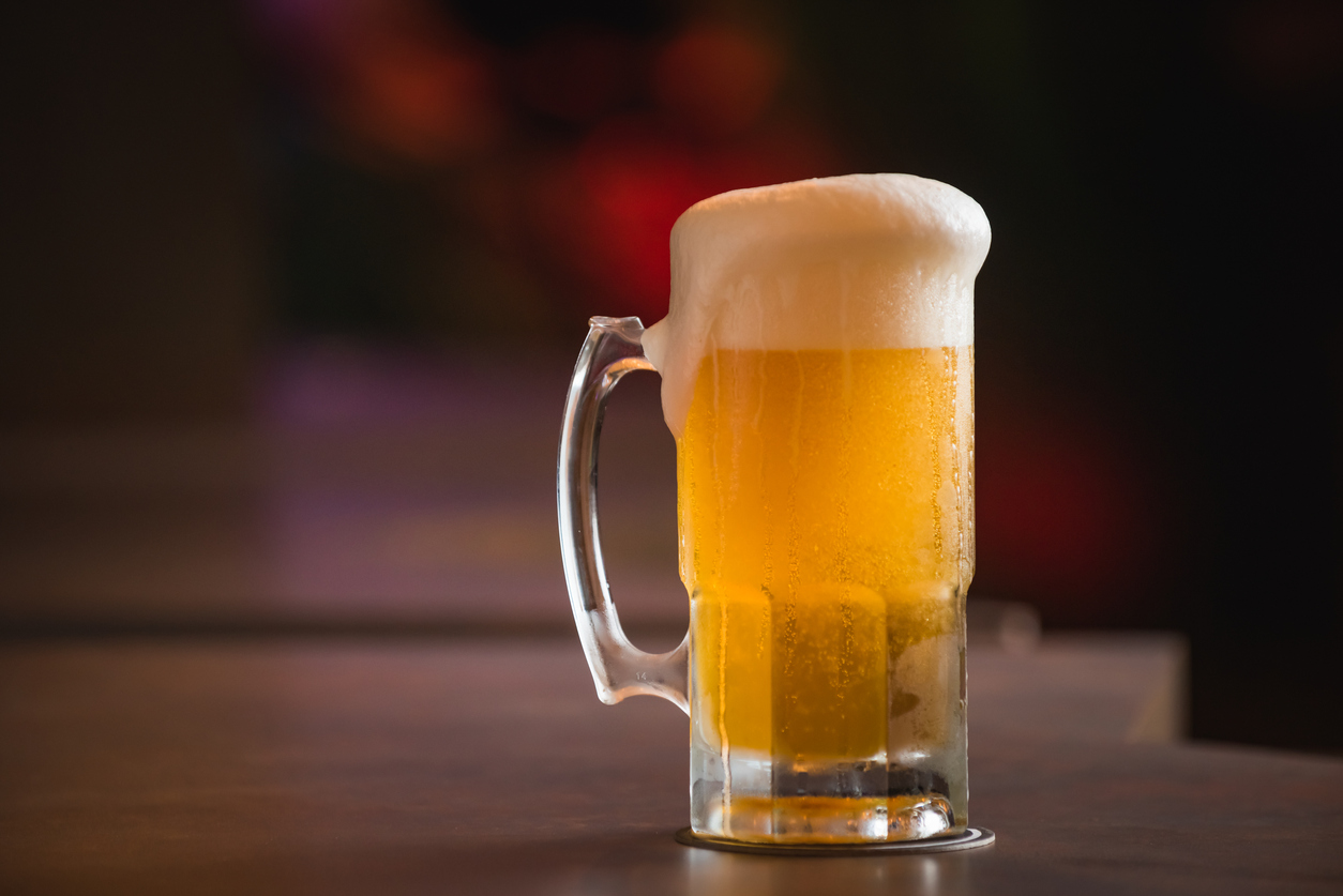 mug full of chopp, with chopp pilsen on a rustic table.