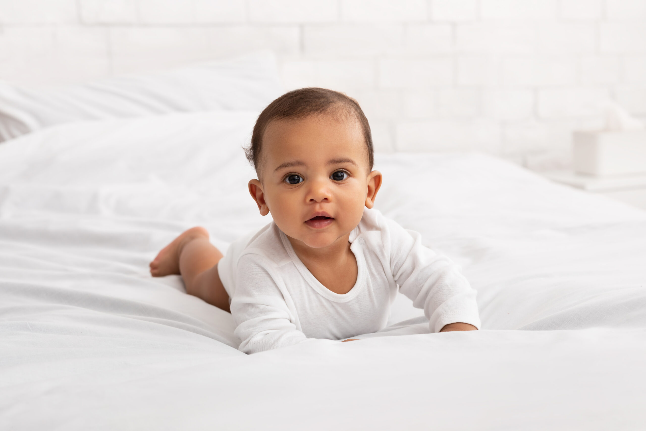 Adorable Black Baby Toddler Crawling On Bed In Bedroom Indoor