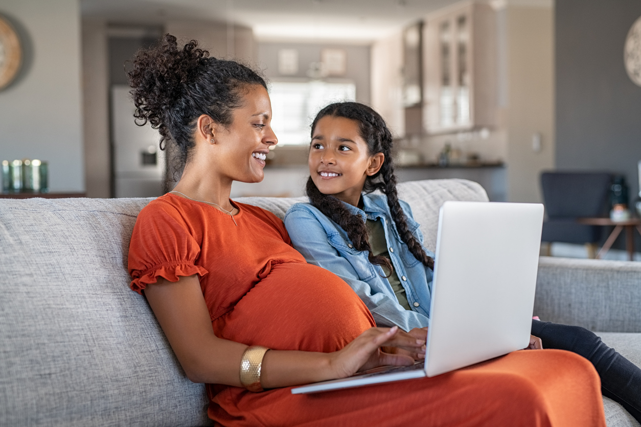 African pregnant woman working rom home in maternity leave