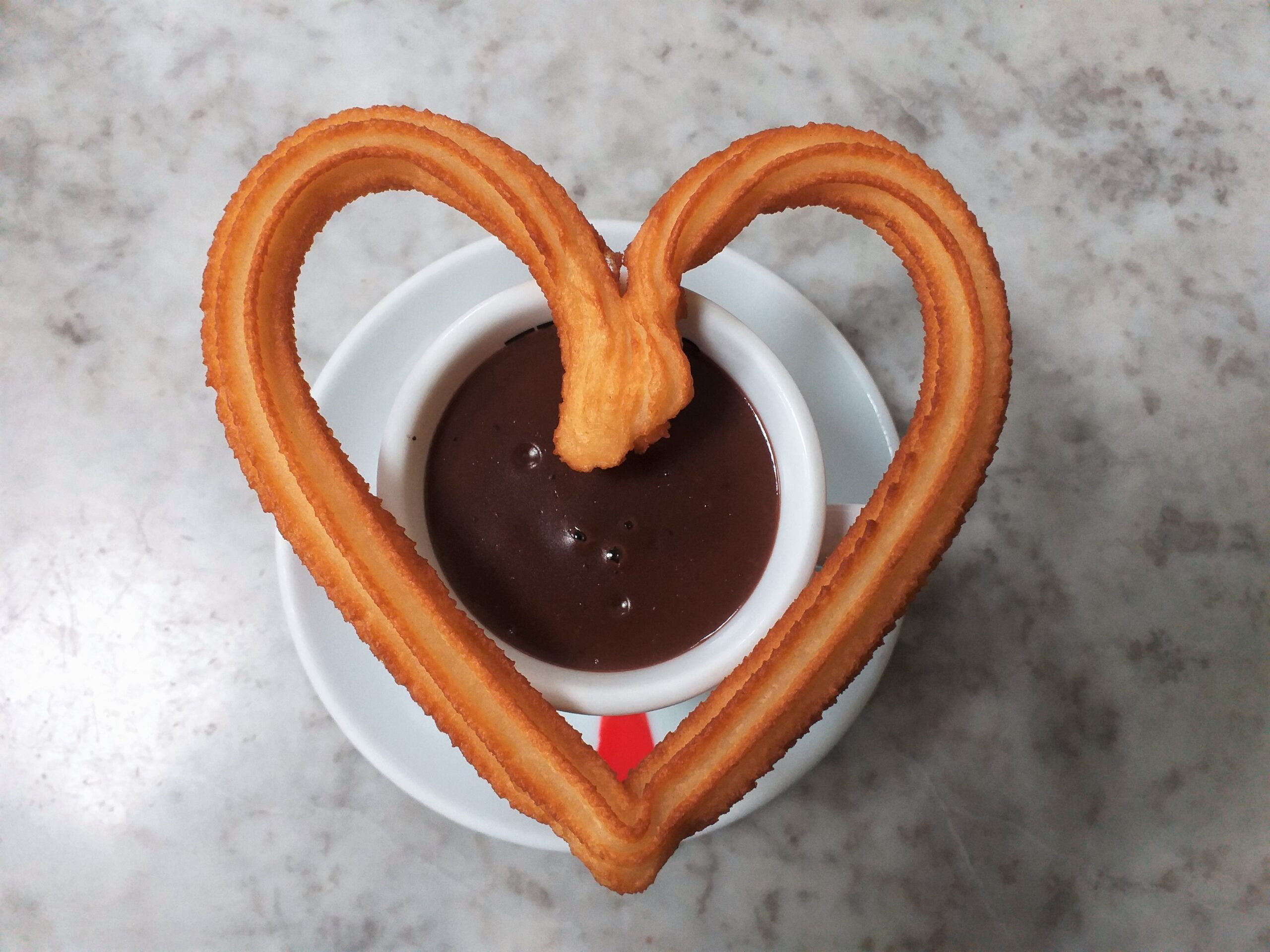 Hot chocolate cup with heart shape of fried-dough pastry