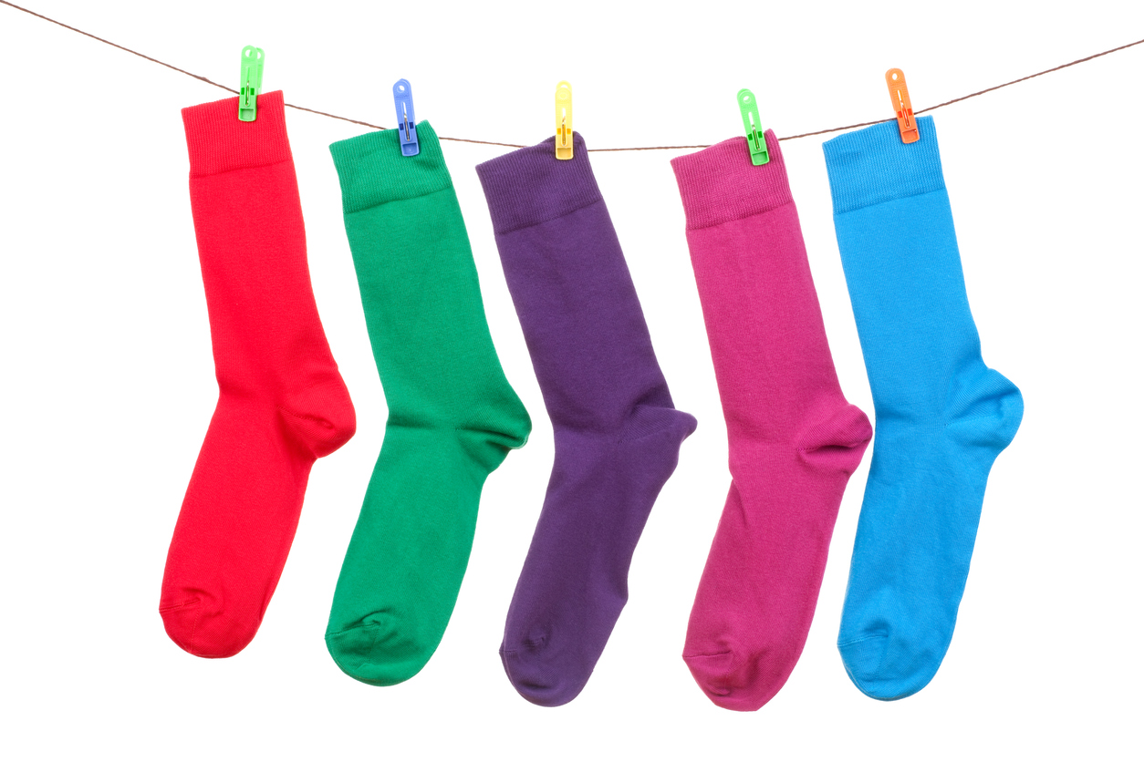 five different color socks hang on rope