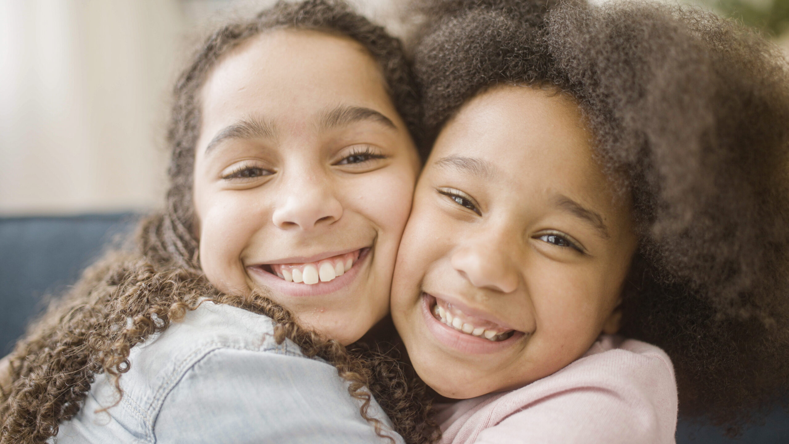 Loving black sisters hugging and smiling sincerely, family support and care