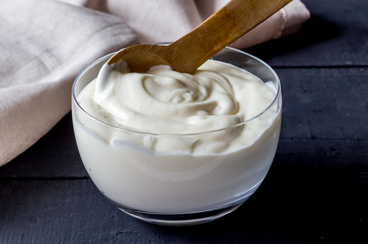 Yogurt in bowl on rustic black table - Photo of plain natural organic yoghurt close up.