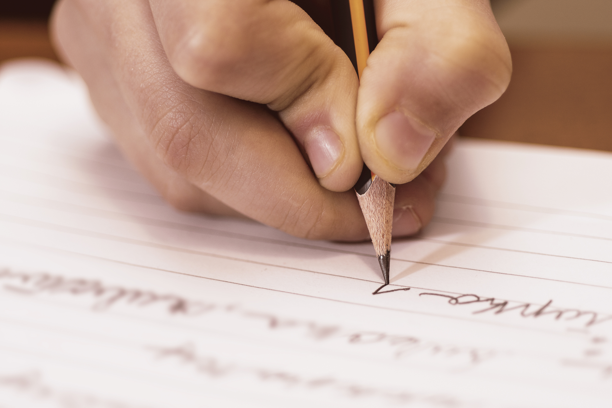 School Boy Writing Close Up. Pencil in Children Hand.