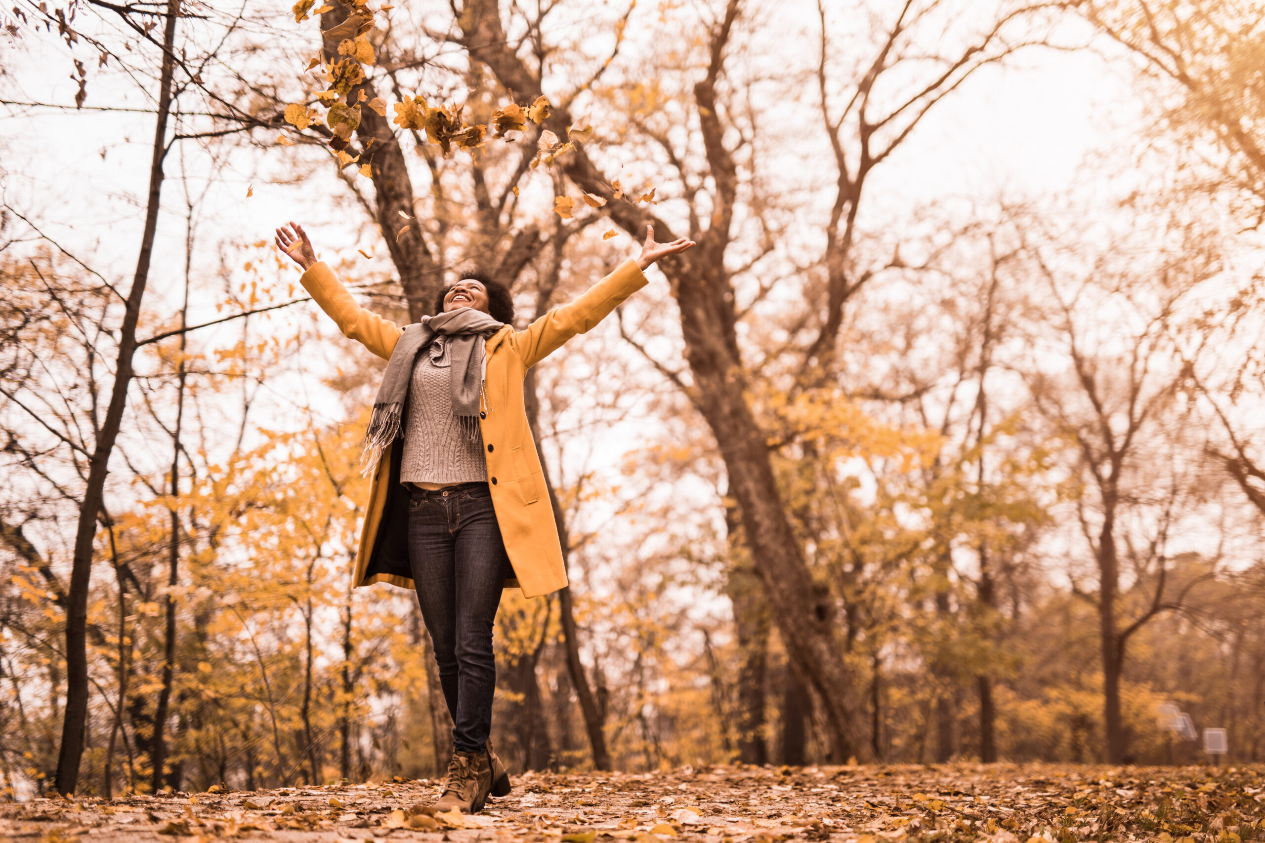 Cheerful mid adult woman enjoying a beautiful autumn day in nature.