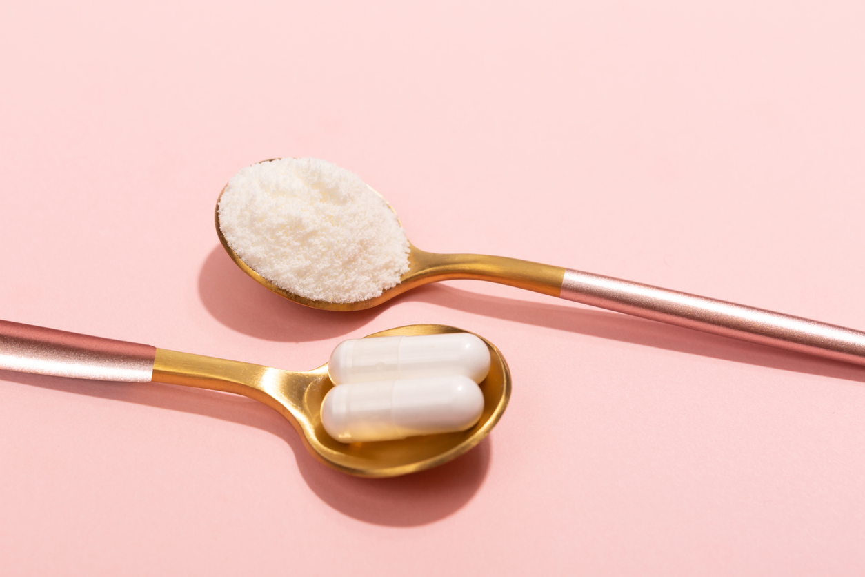 Collagen powder and pills on pink background