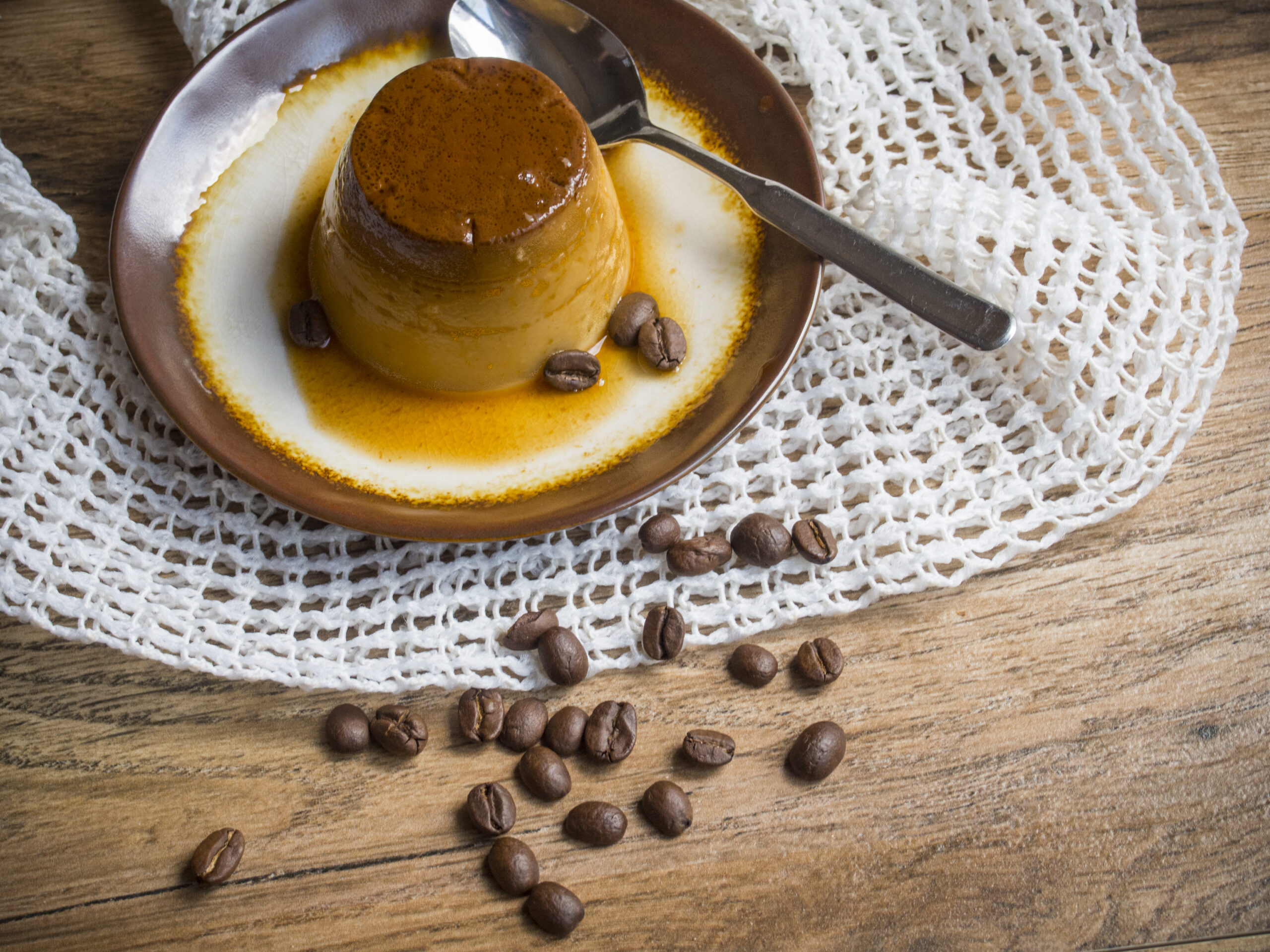 Coffee flan in a plate on wood background