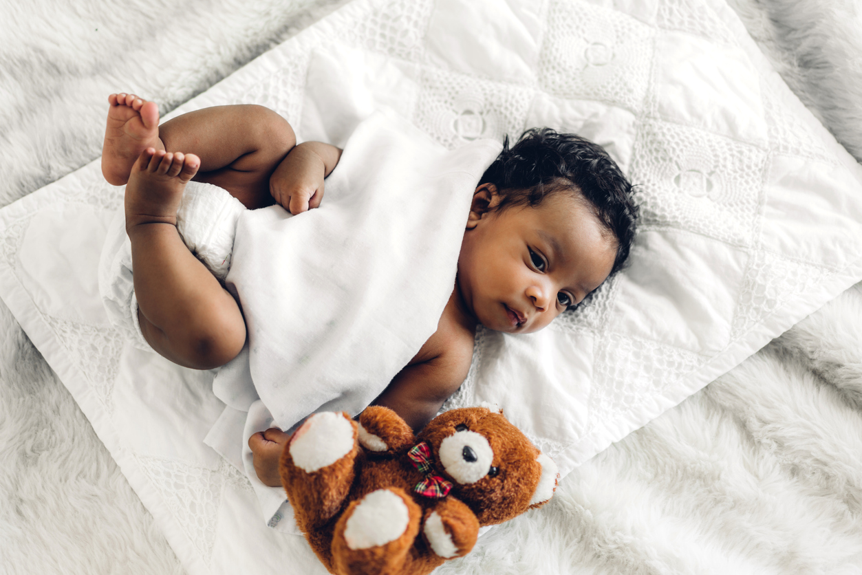 Portrait of cute adorable little african american baby sleep in a white bedroom