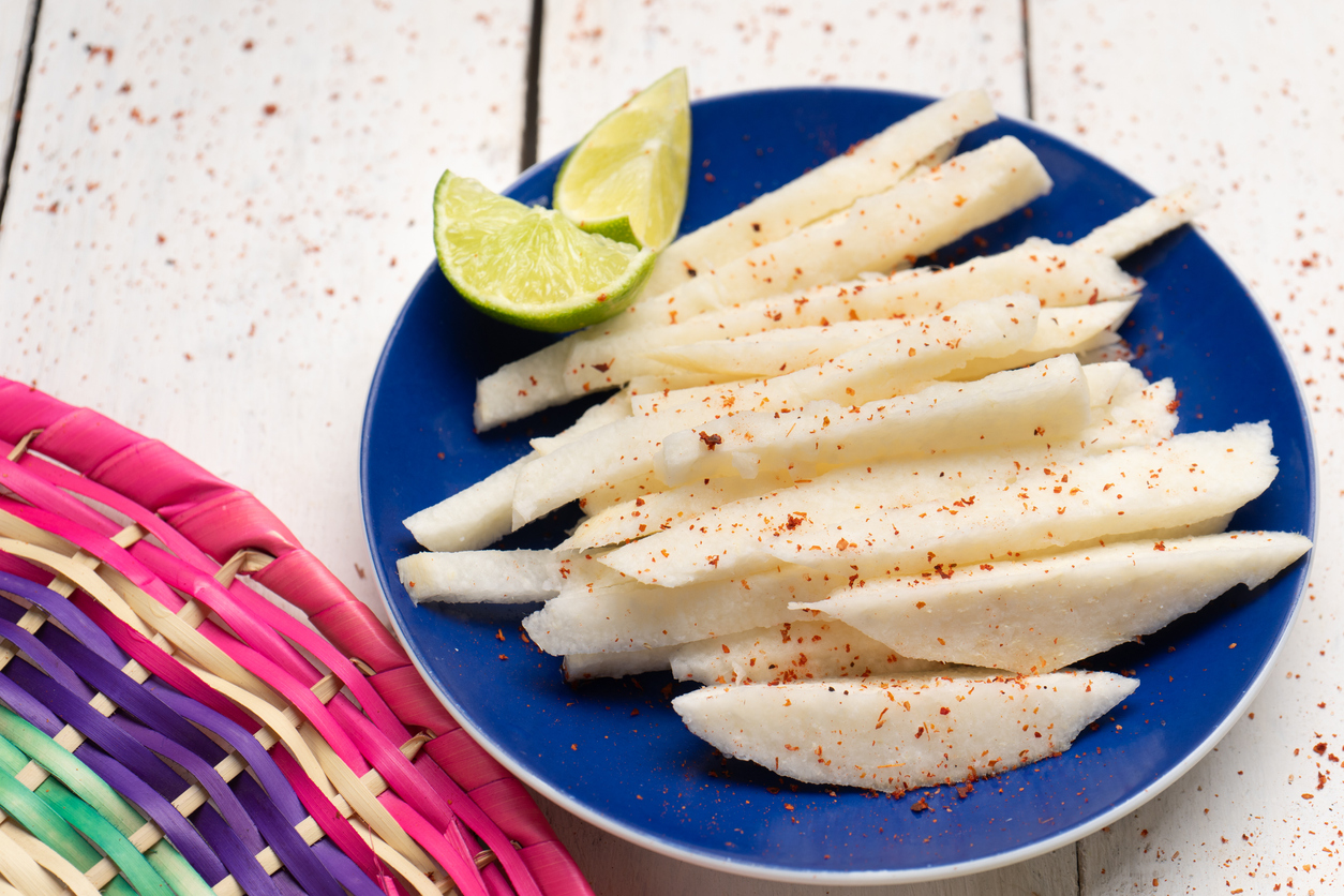 Mexican jicama  cutted with chili powder on white background