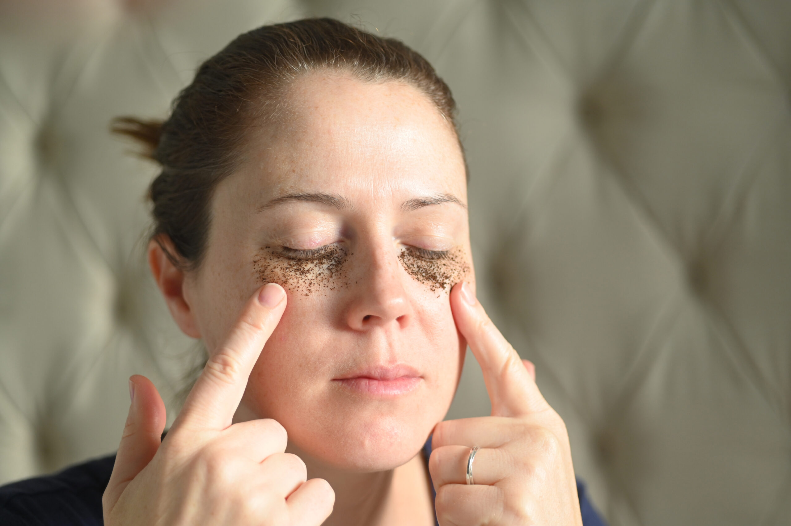 Woman relaxing at home with coffee grounds on her face