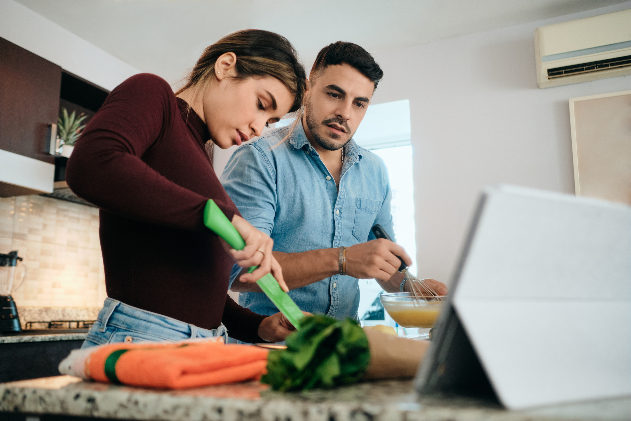 Couple Cooking Together Watching Tutorial For Recipe