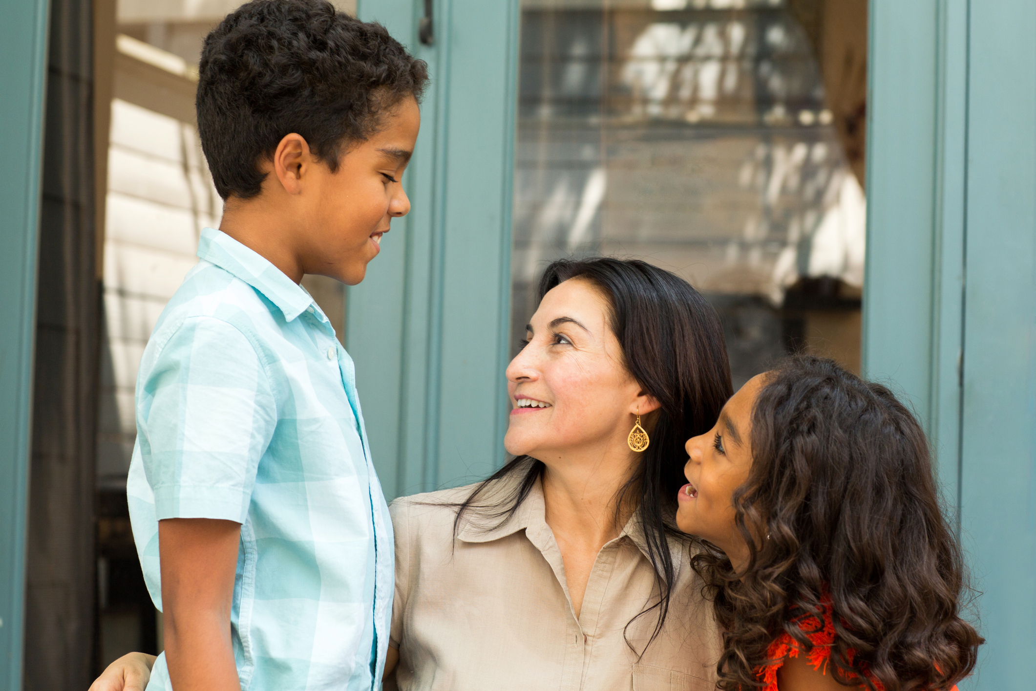 Happy Hispanic mother laughing and talking with her children