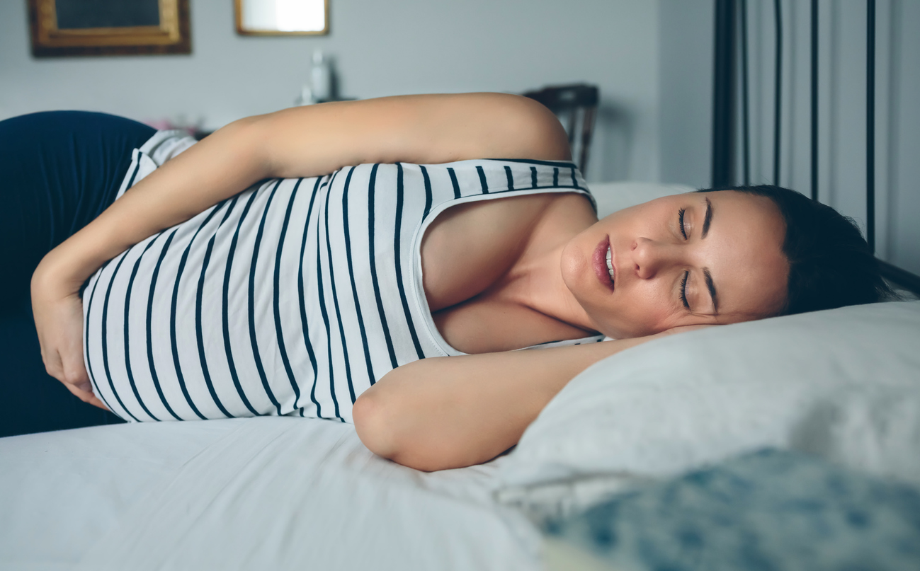 Pregnant woman sleeping in bed