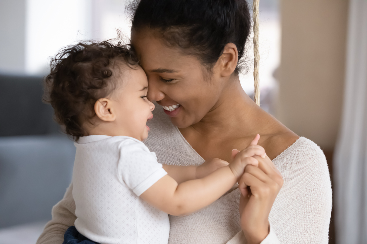 Loving biracial mom hug cute little baby child