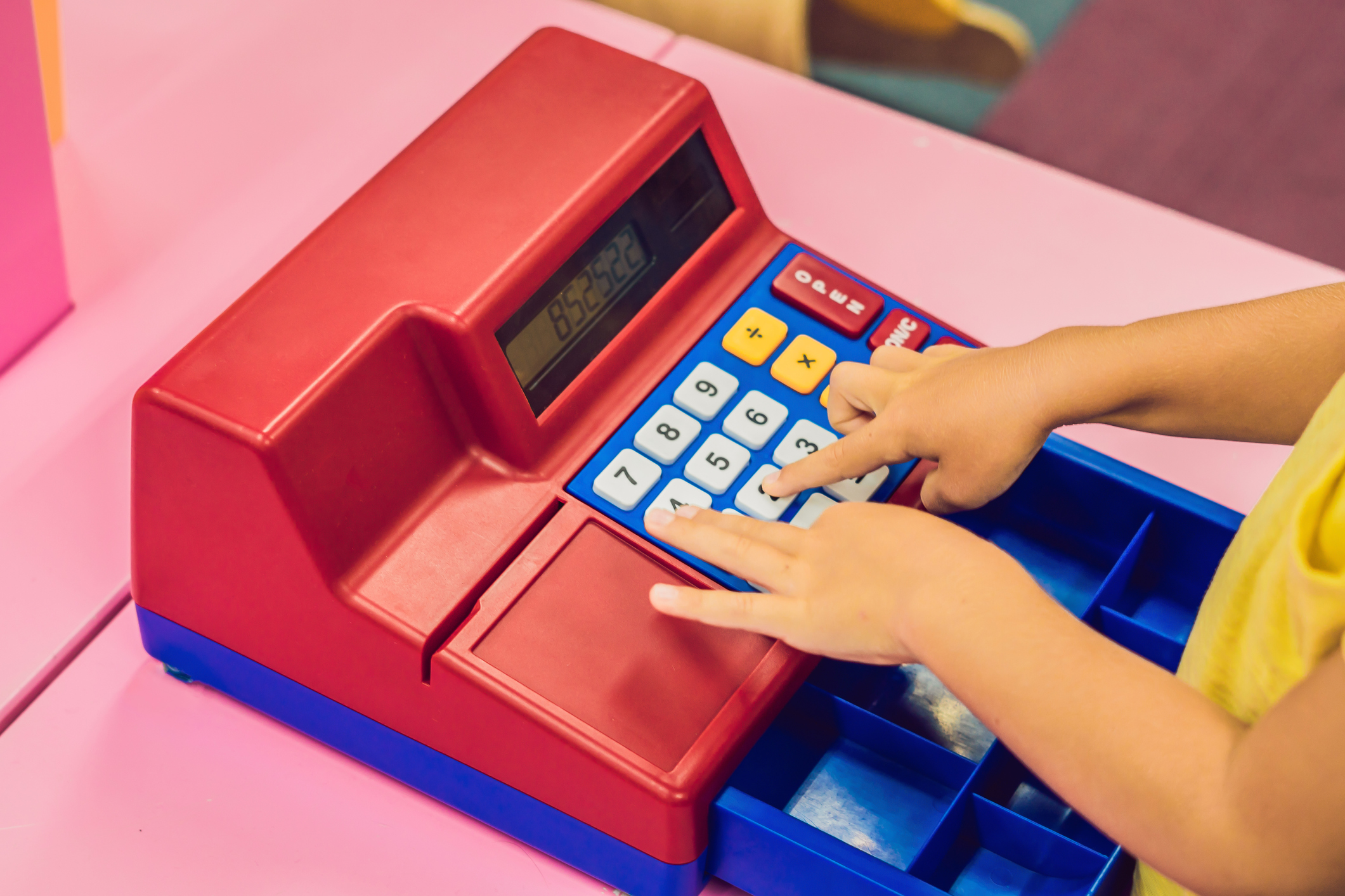 The boy plays with the children's cash register