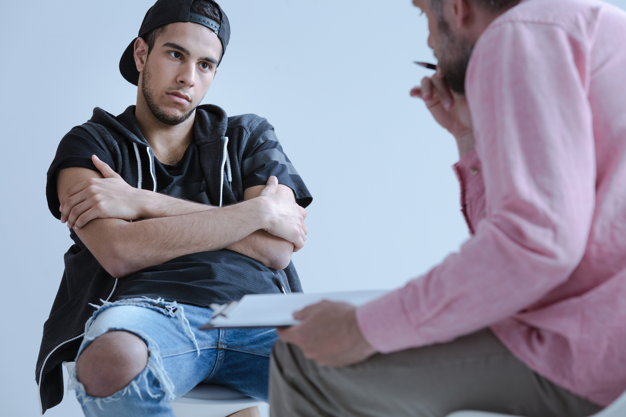 A withdrawn rebel young boy with behavioral and social disorders during his individual meeting with a psychotherapist.