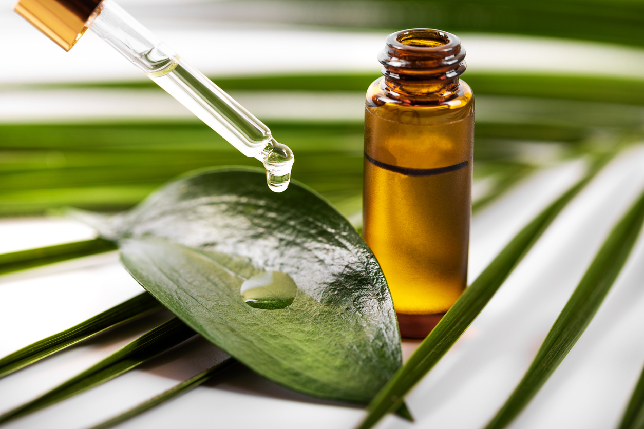 essential oil dripping on the green leaf from pipette