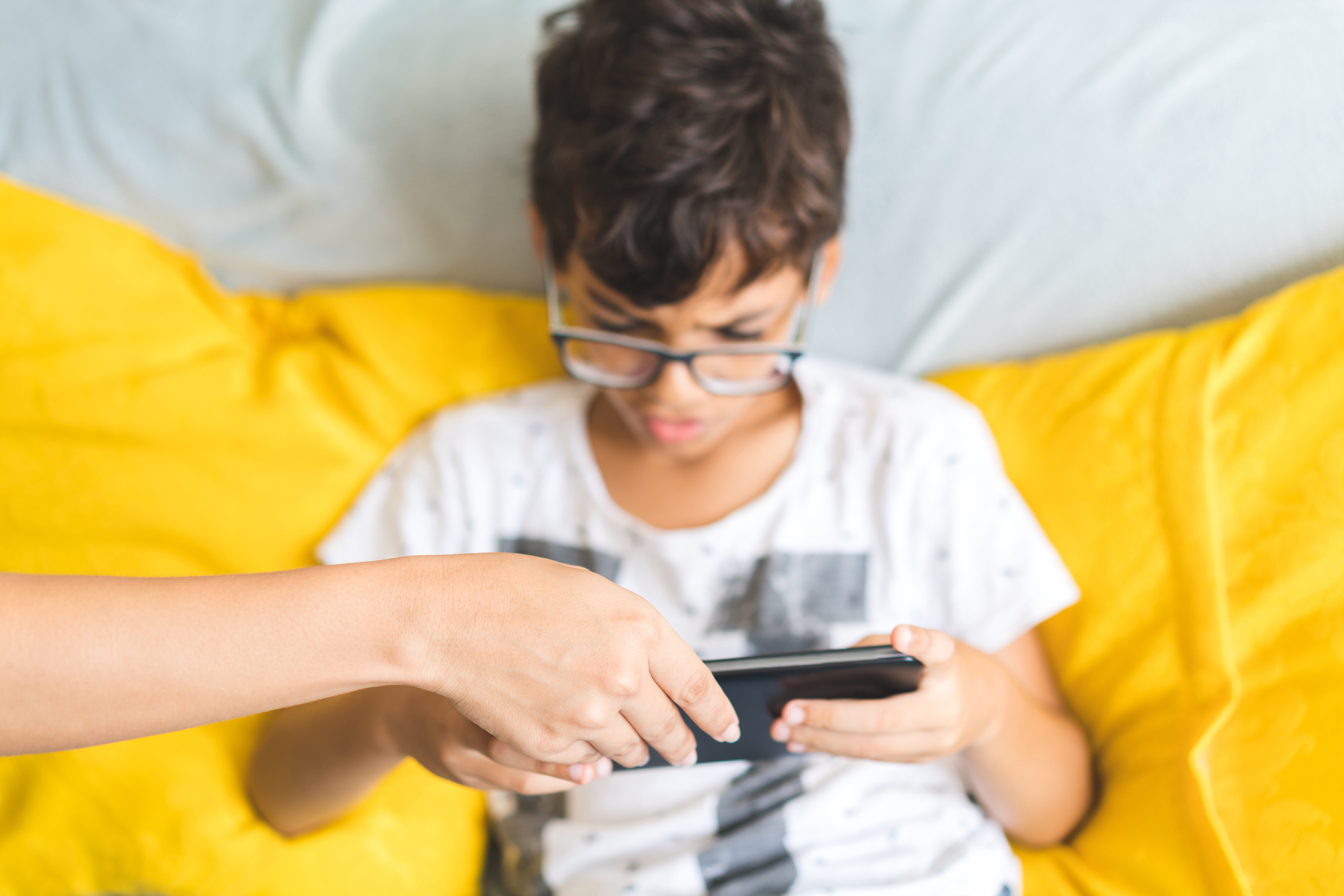 Mother takes the digital tablet of her child