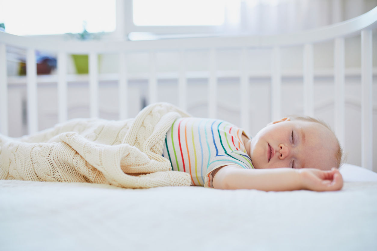 Baby girl sleeping in co-sleeper crib