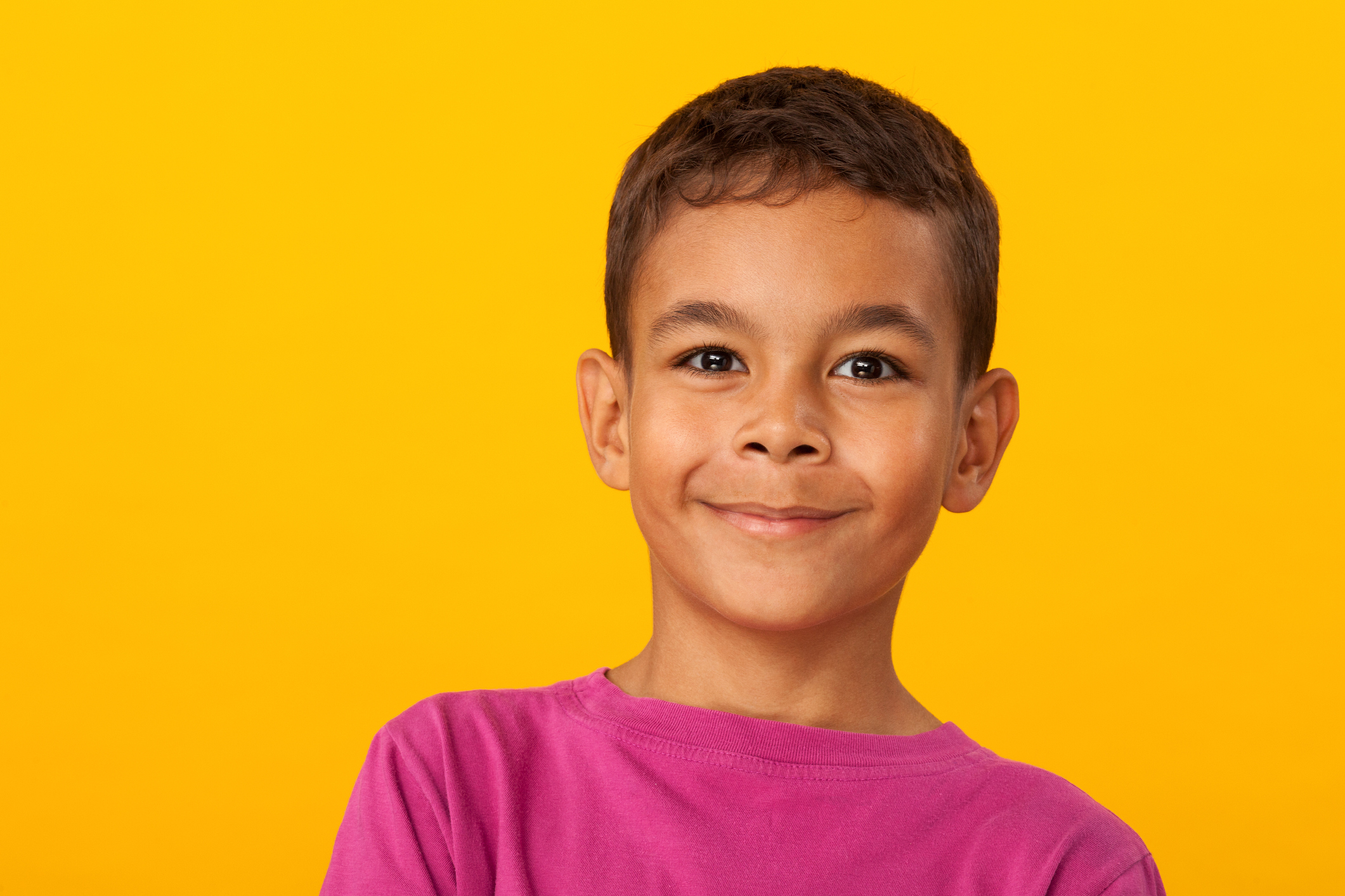 studio portrait of a 10 year old schoolboy on a yellow background