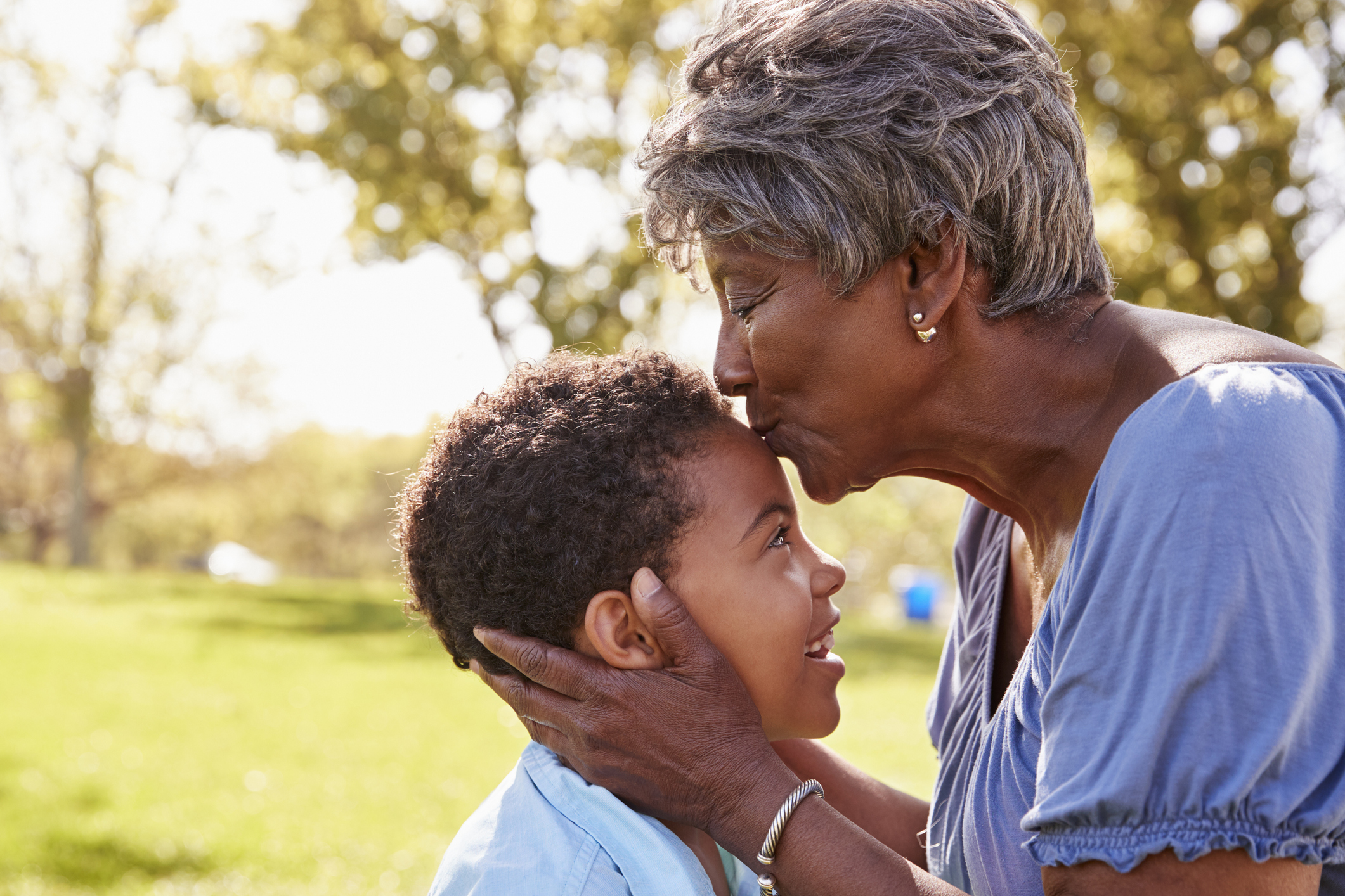 Close Up Of Grandmother Kissing Grandson In Park