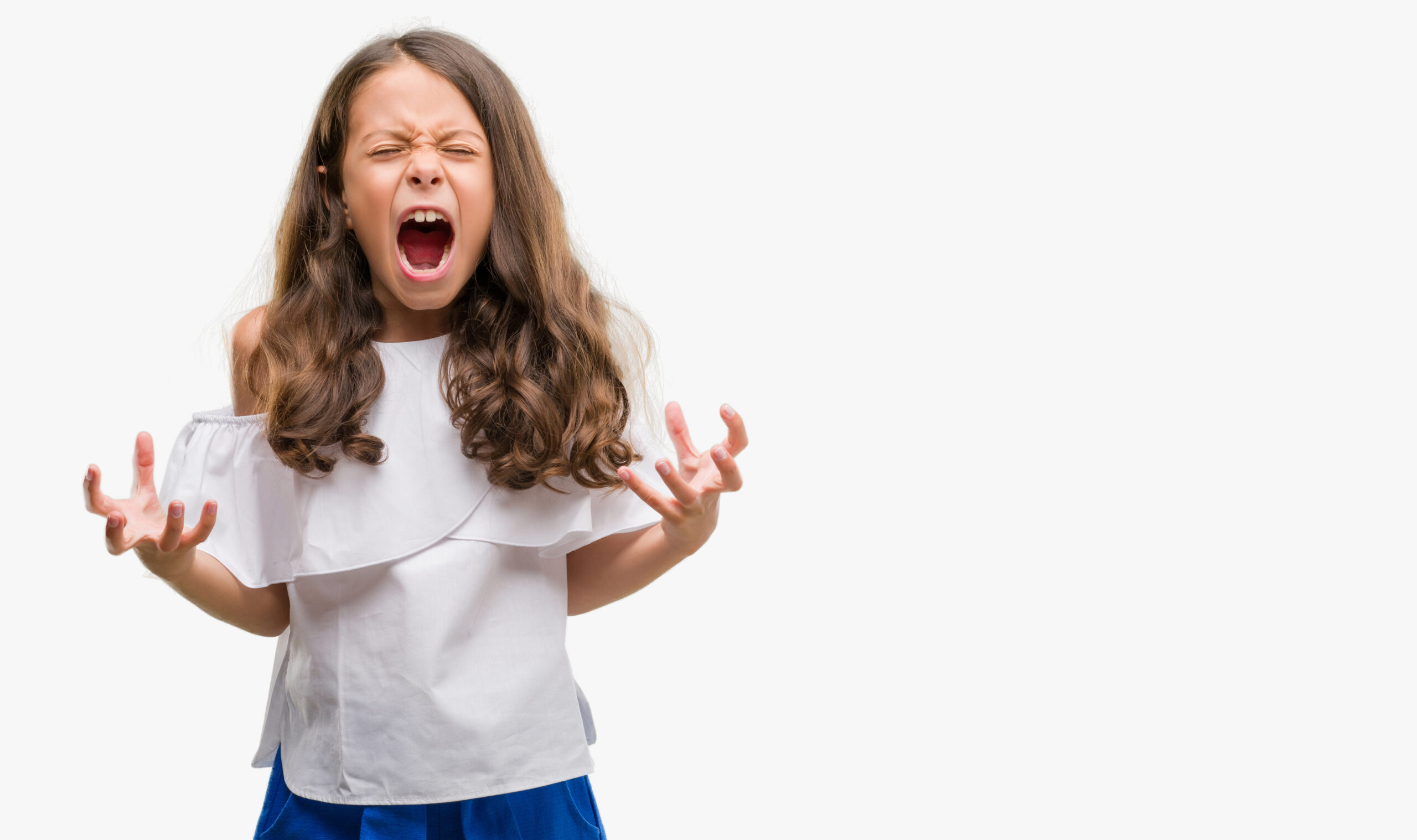 Brunette hispanic girl crazy and mad shouting and yelling with aggressive expression and arms raised. Frustration concept.