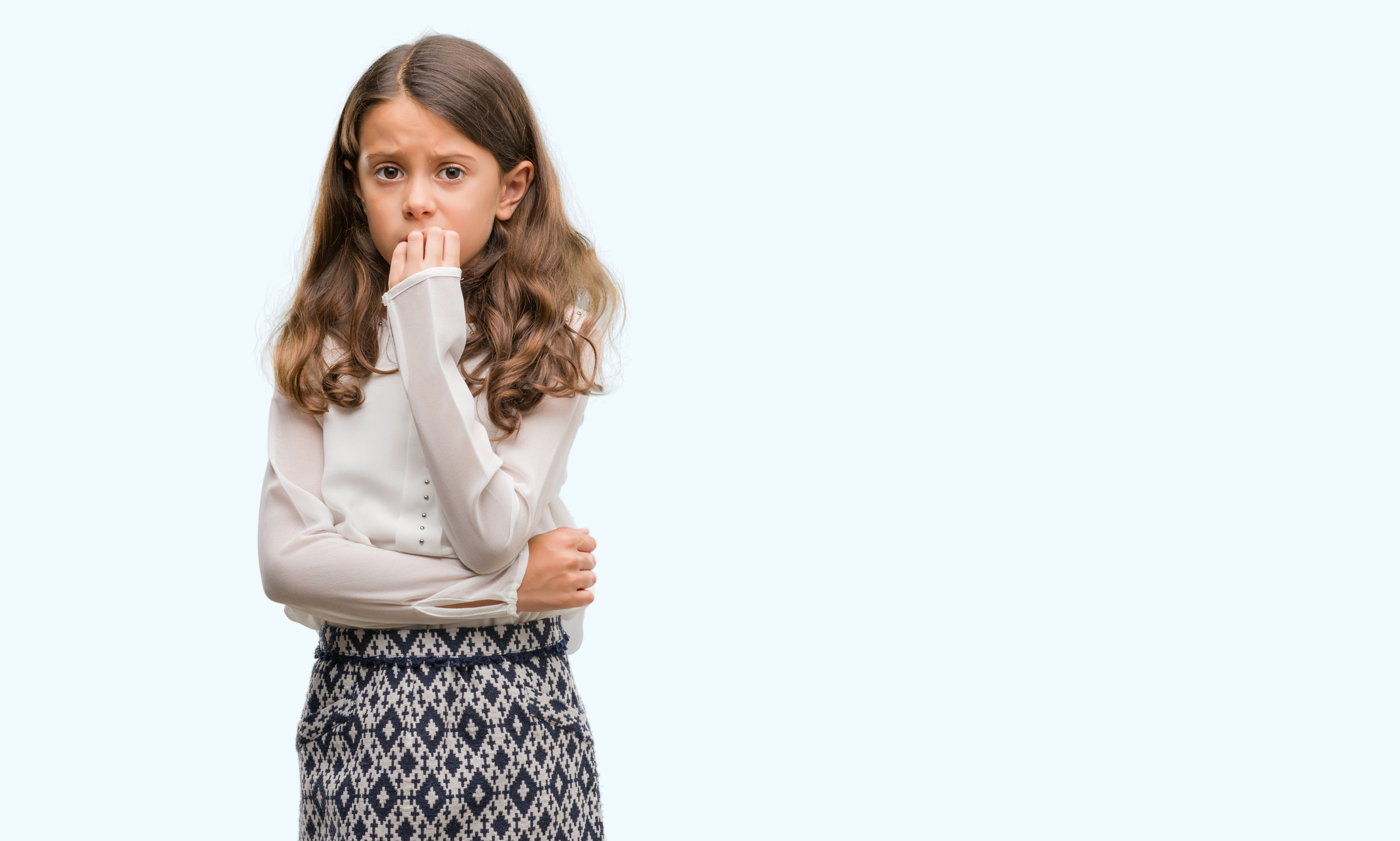 Brunette hispanic girl looking stressed and nervous with hands on mouth biting nails. Anxiety problem.