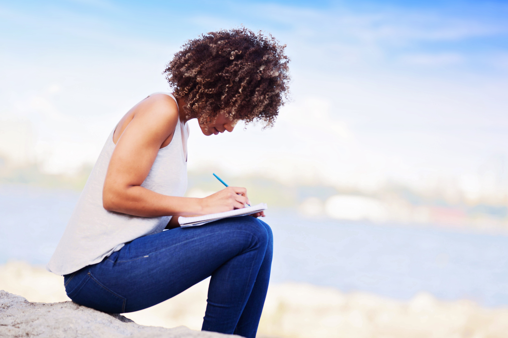 Woman Writing in a Notebook Outdoors