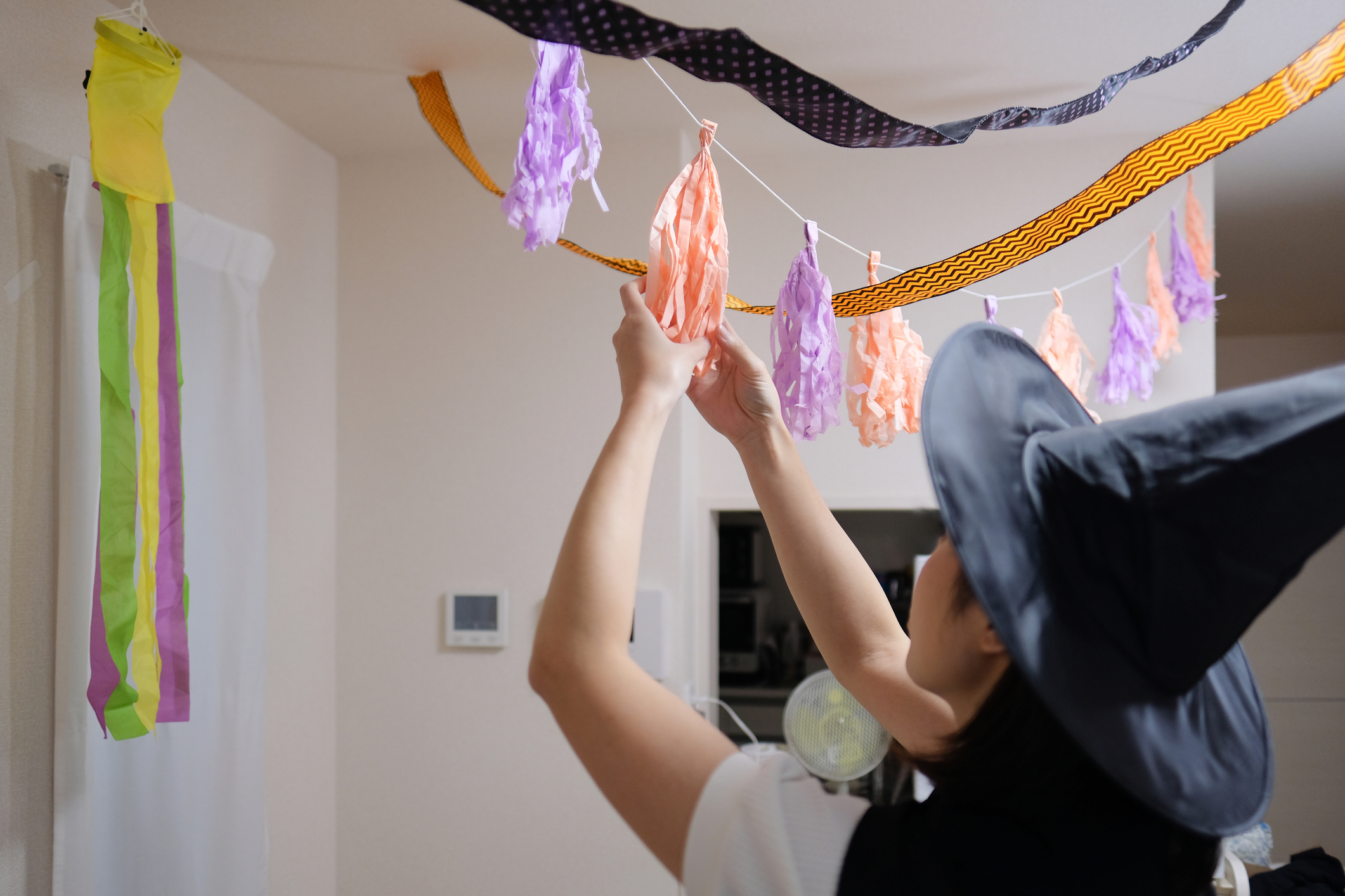 Woman with witch hat decorating ornament for Halloween